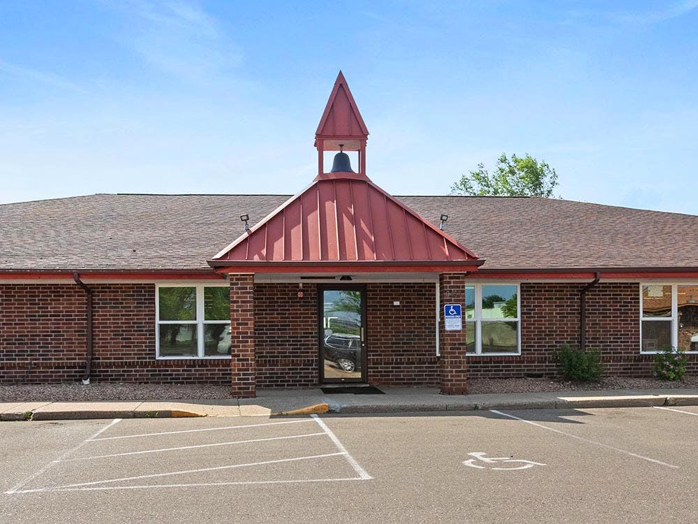 Brick building with a red roof and bell tower