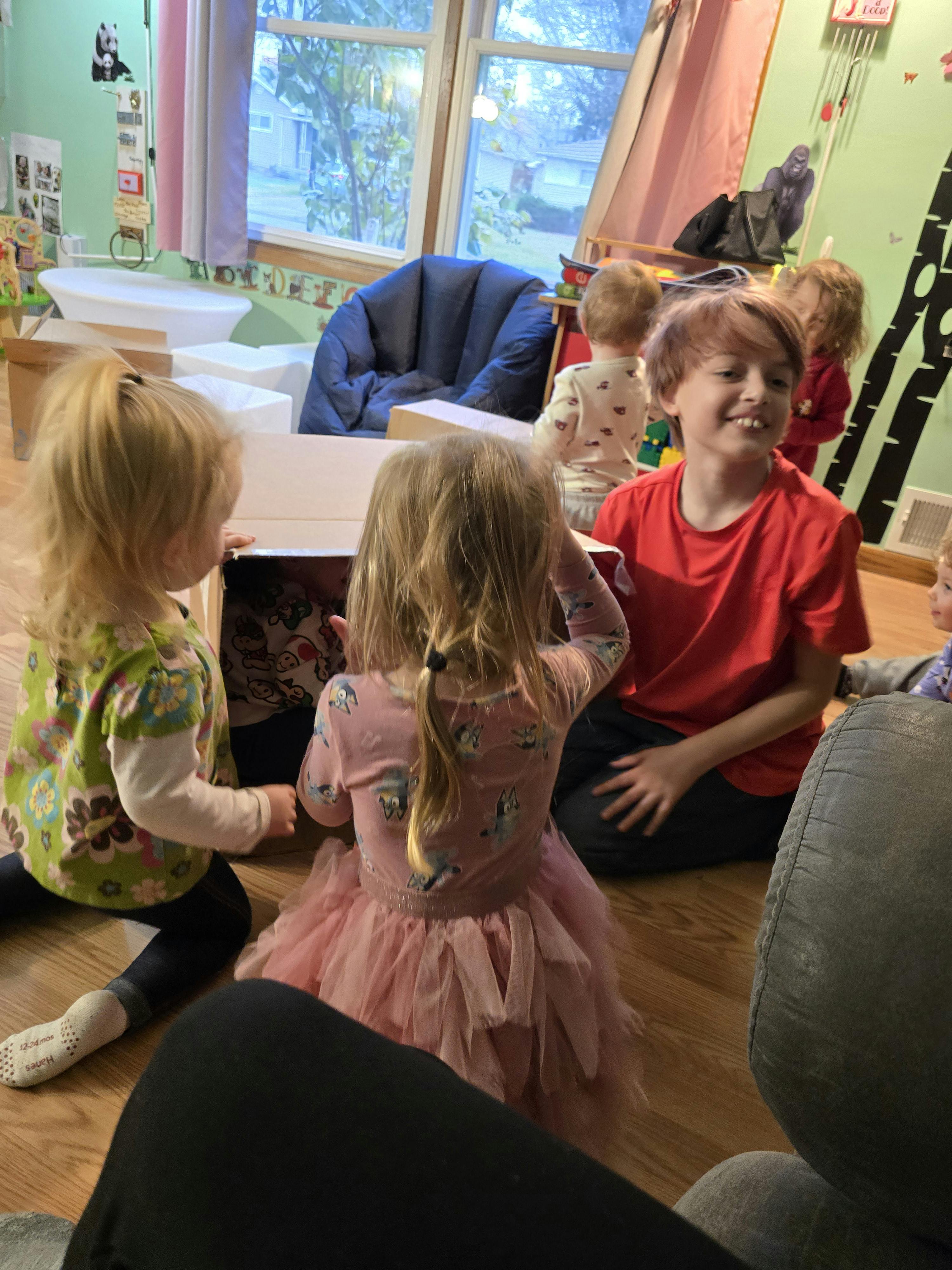 Children playing with a box in a classroom
