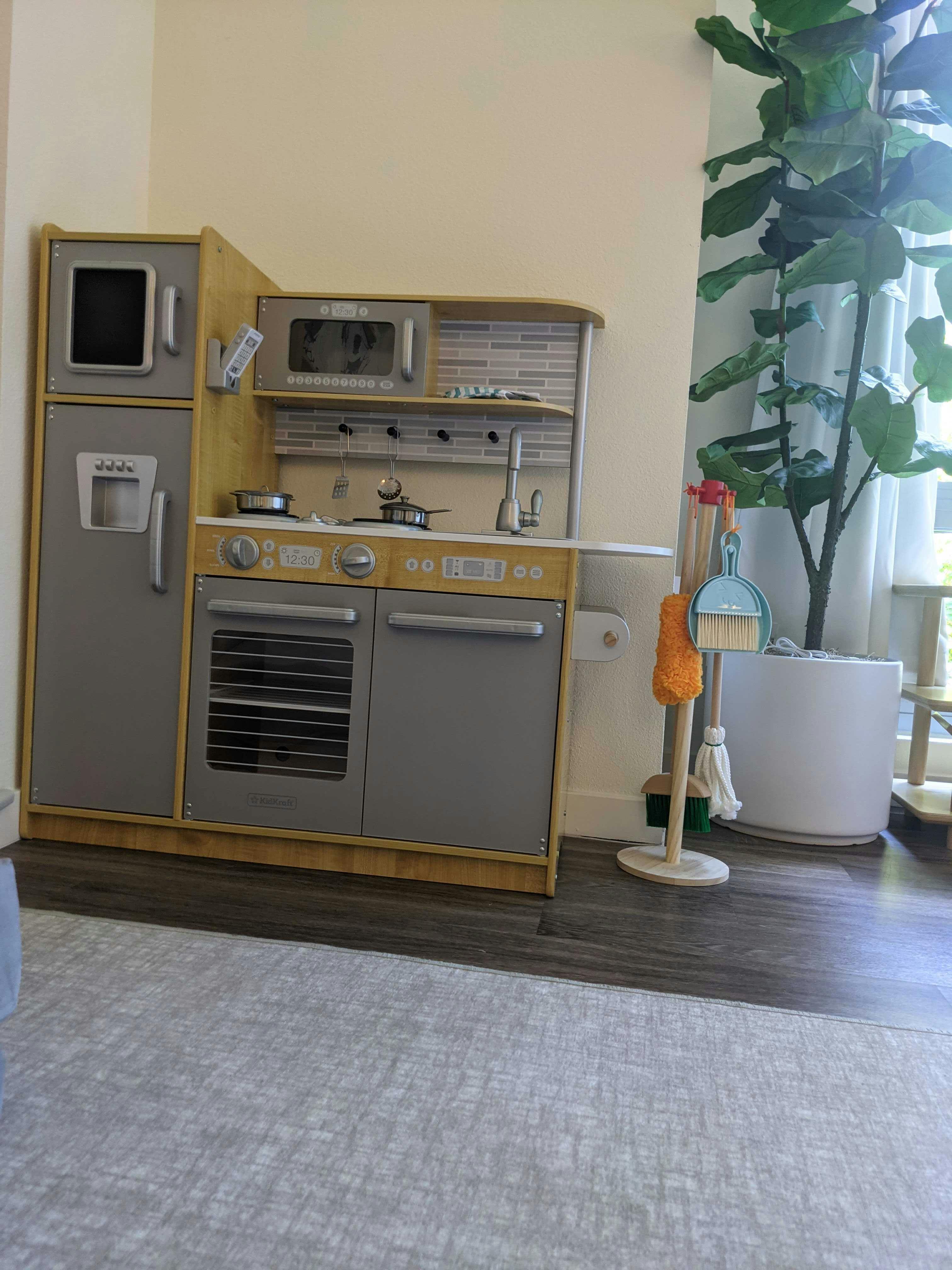 Child's play kitchen with refrigerator, oven, and microwave