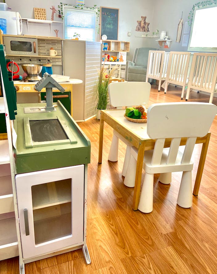 Play kitchen and small table with chairs in a room