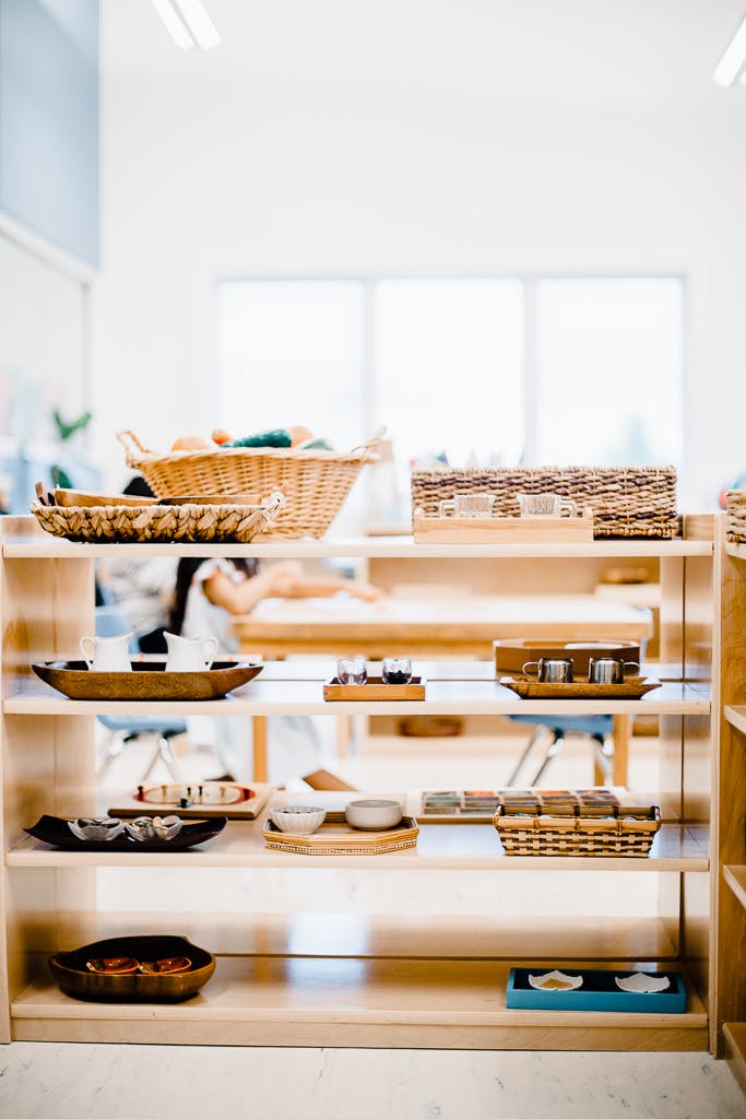 Shelves with baskets and trays of items in a classroom