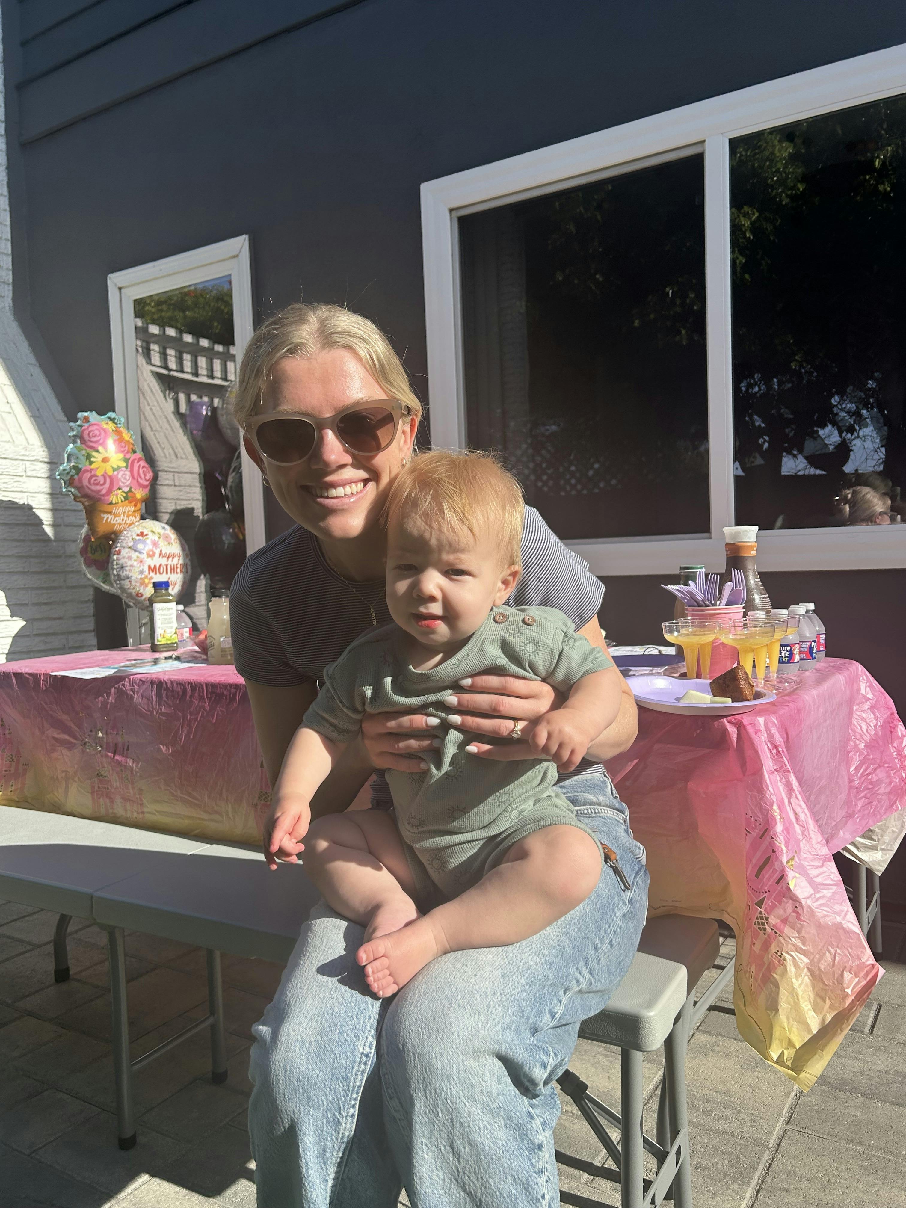 Person in sunglasses holding a child