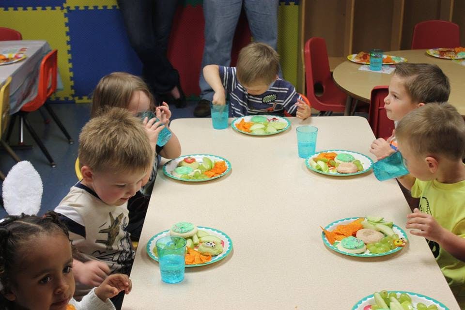 Children eating at a table in a classroom