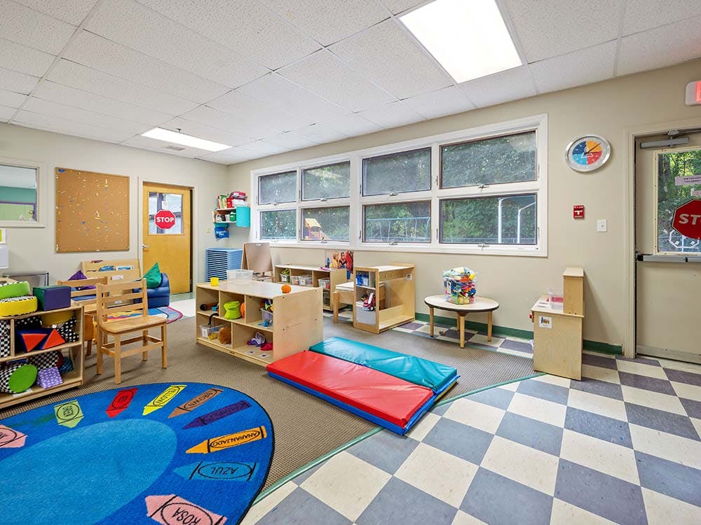Classroom with play furniture, storage, and a colorful rug