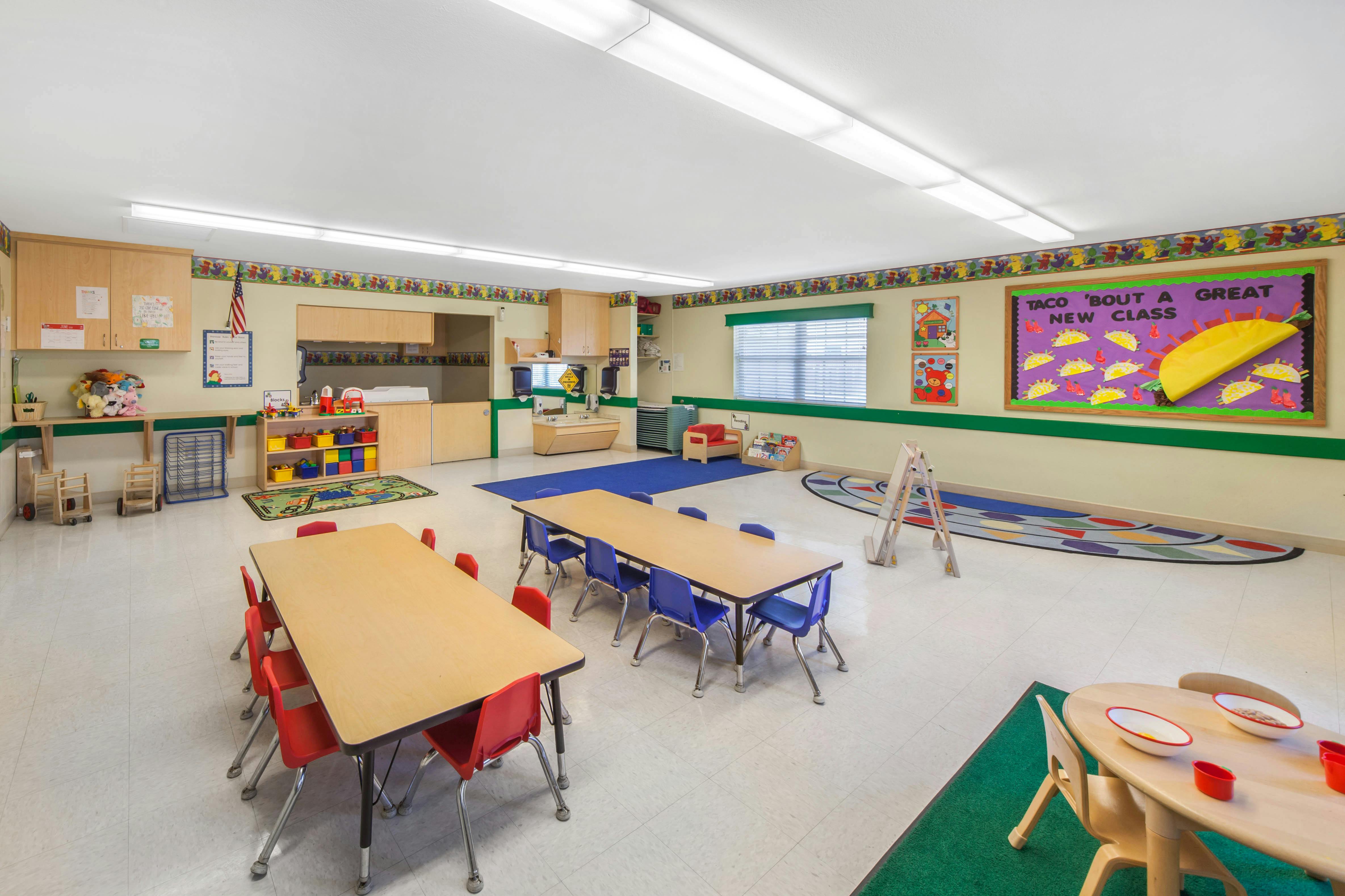 Empty colorful children's classroom with small tables and chairs