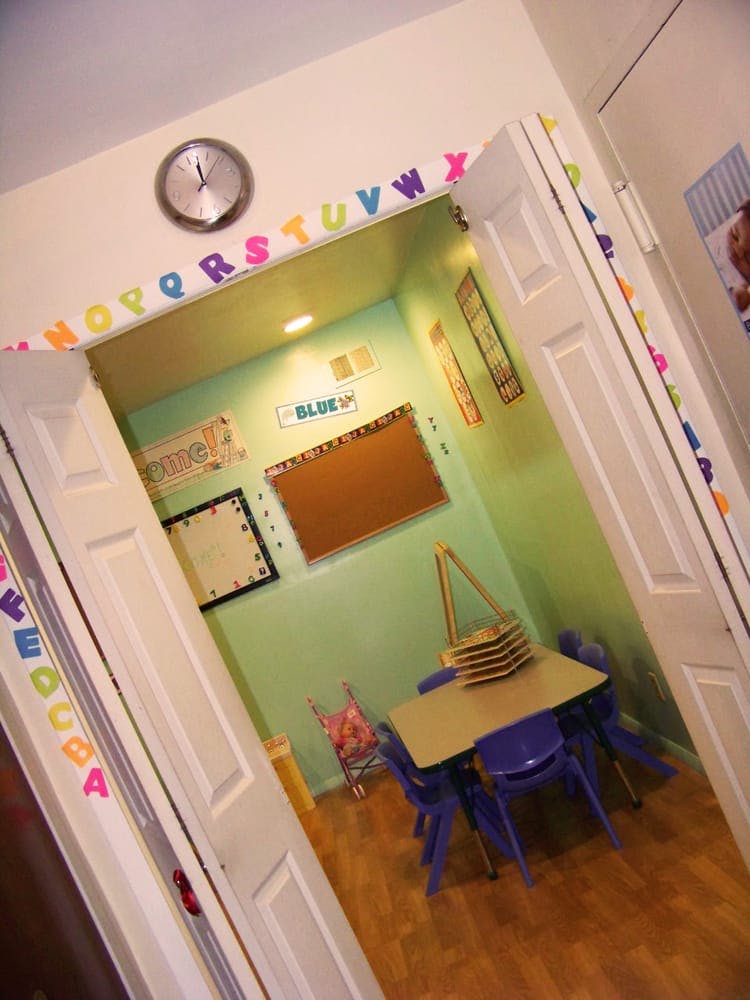 Classroom with small table and chairs, bulletin boards, and alphabet letters