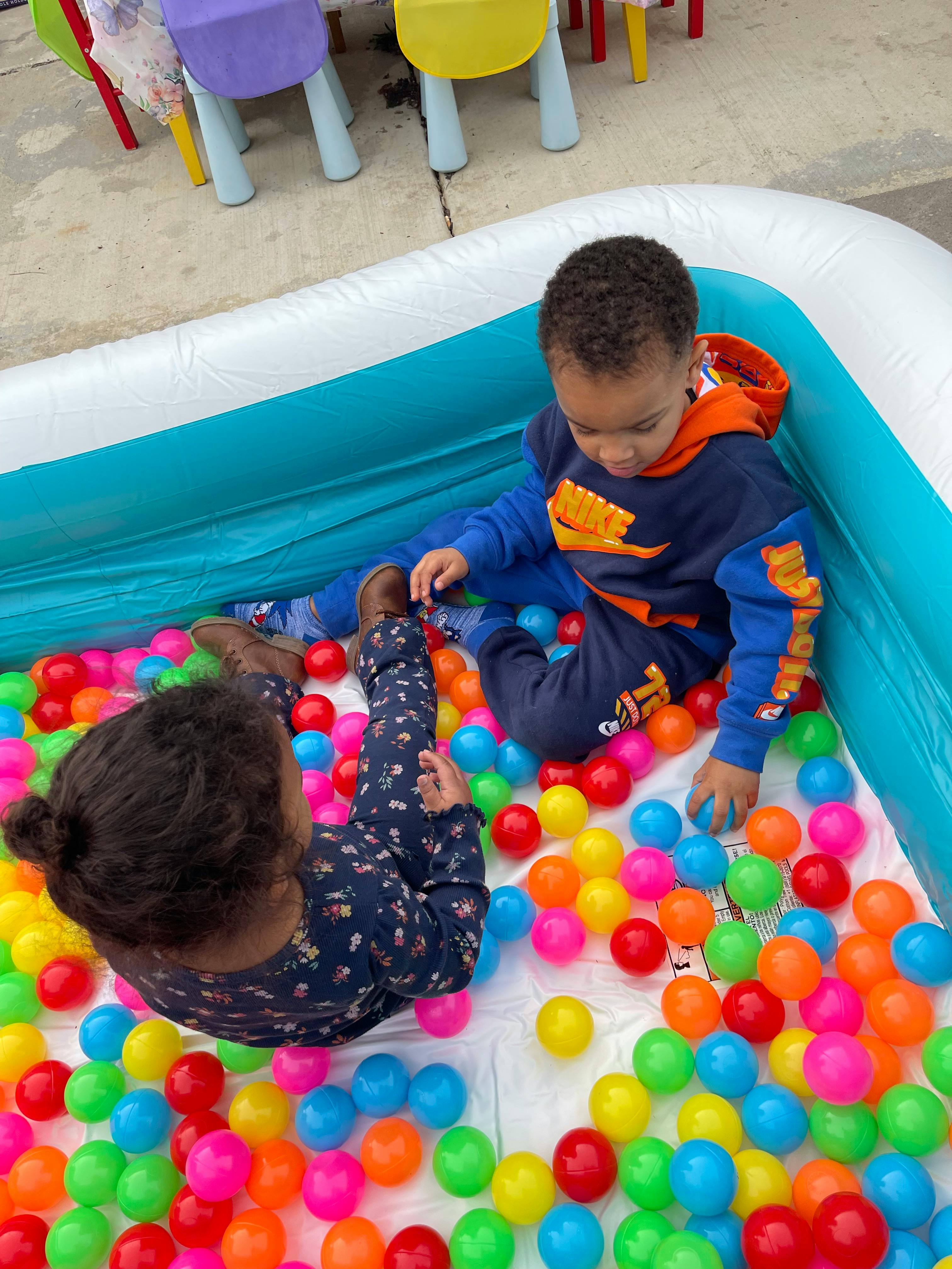 Two children playing in a ball pit