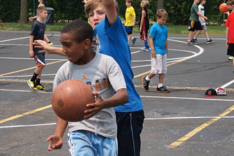 Two children playing basketball on a court