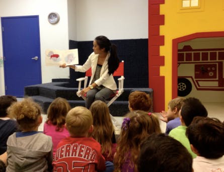Person reading a book to a group of children