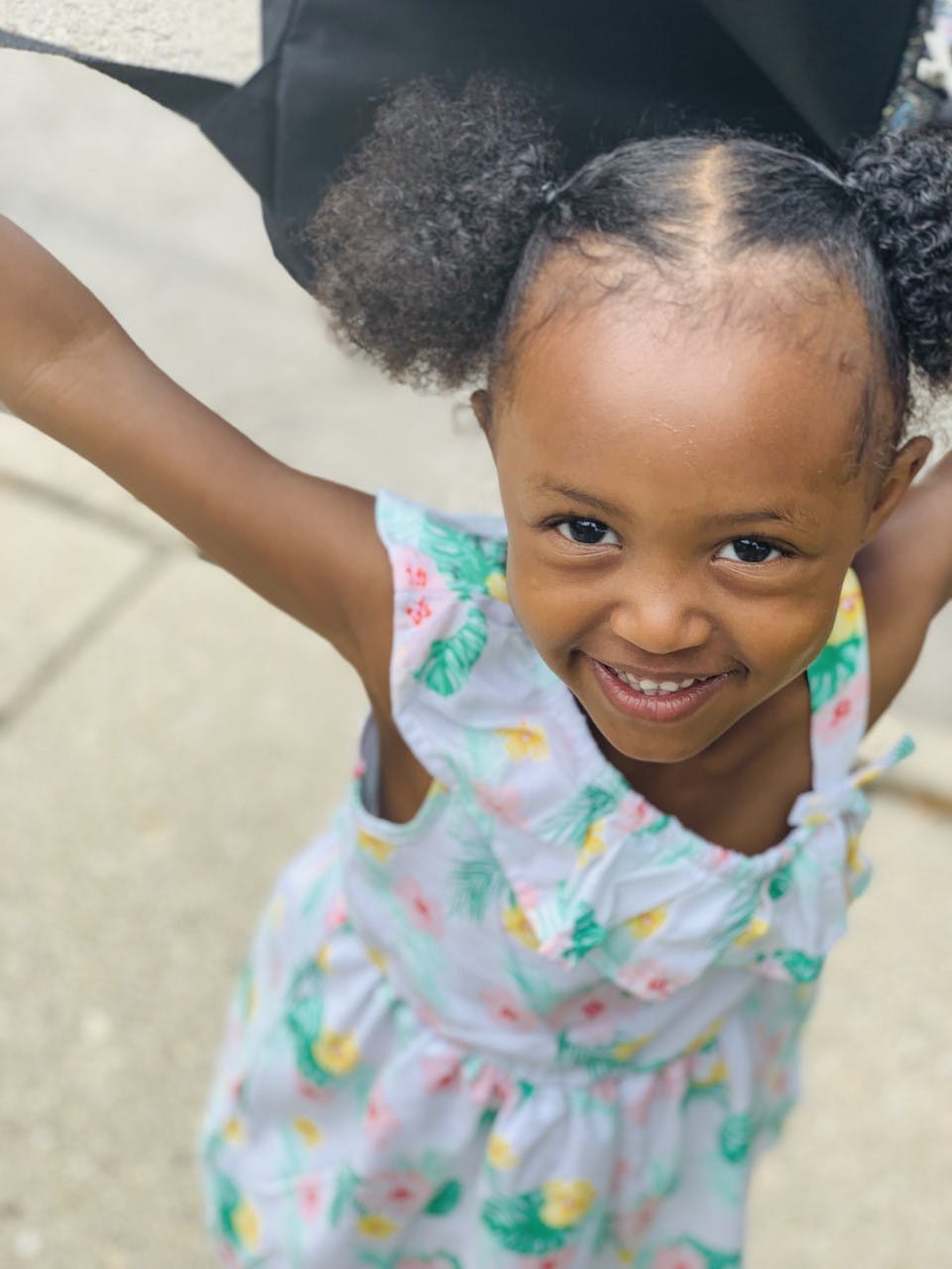 Child with arms outstretched, smiling