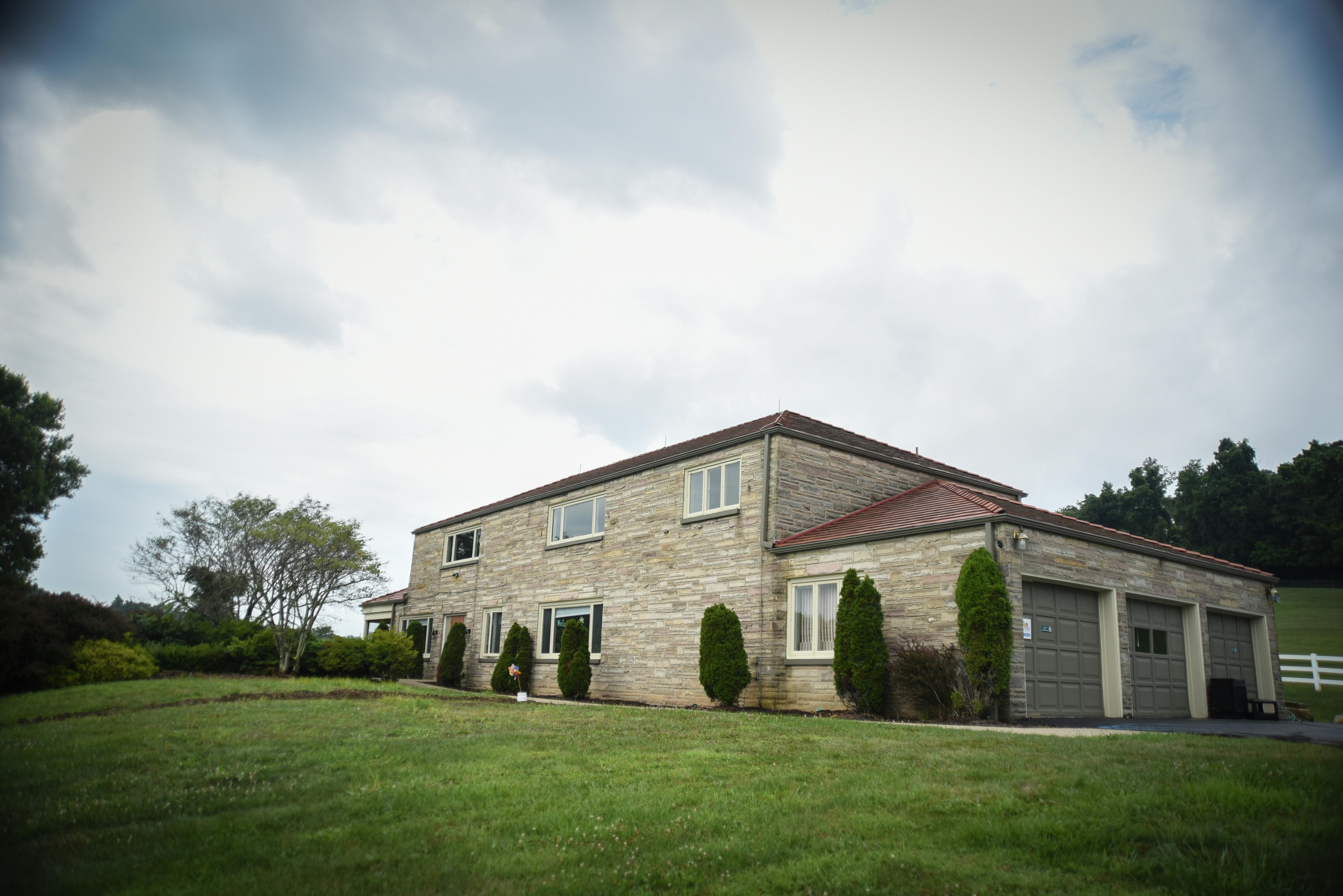 Stone house with a red roof and attached garage