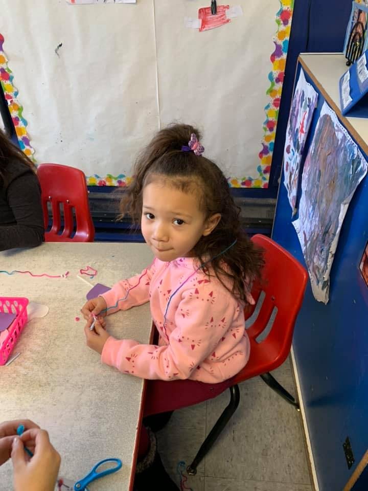 Child sitting at a table in a classroom