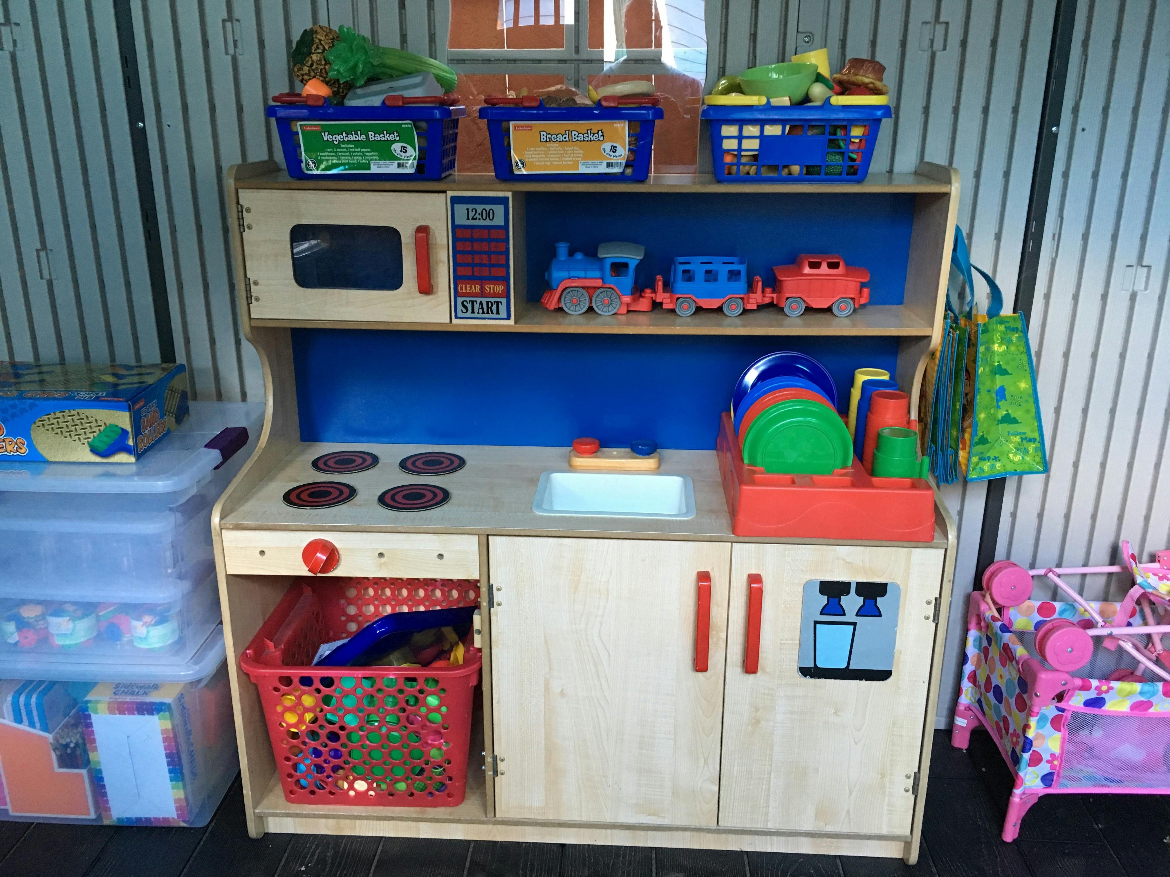 Toy kitchen with play food, dishes, and trains
