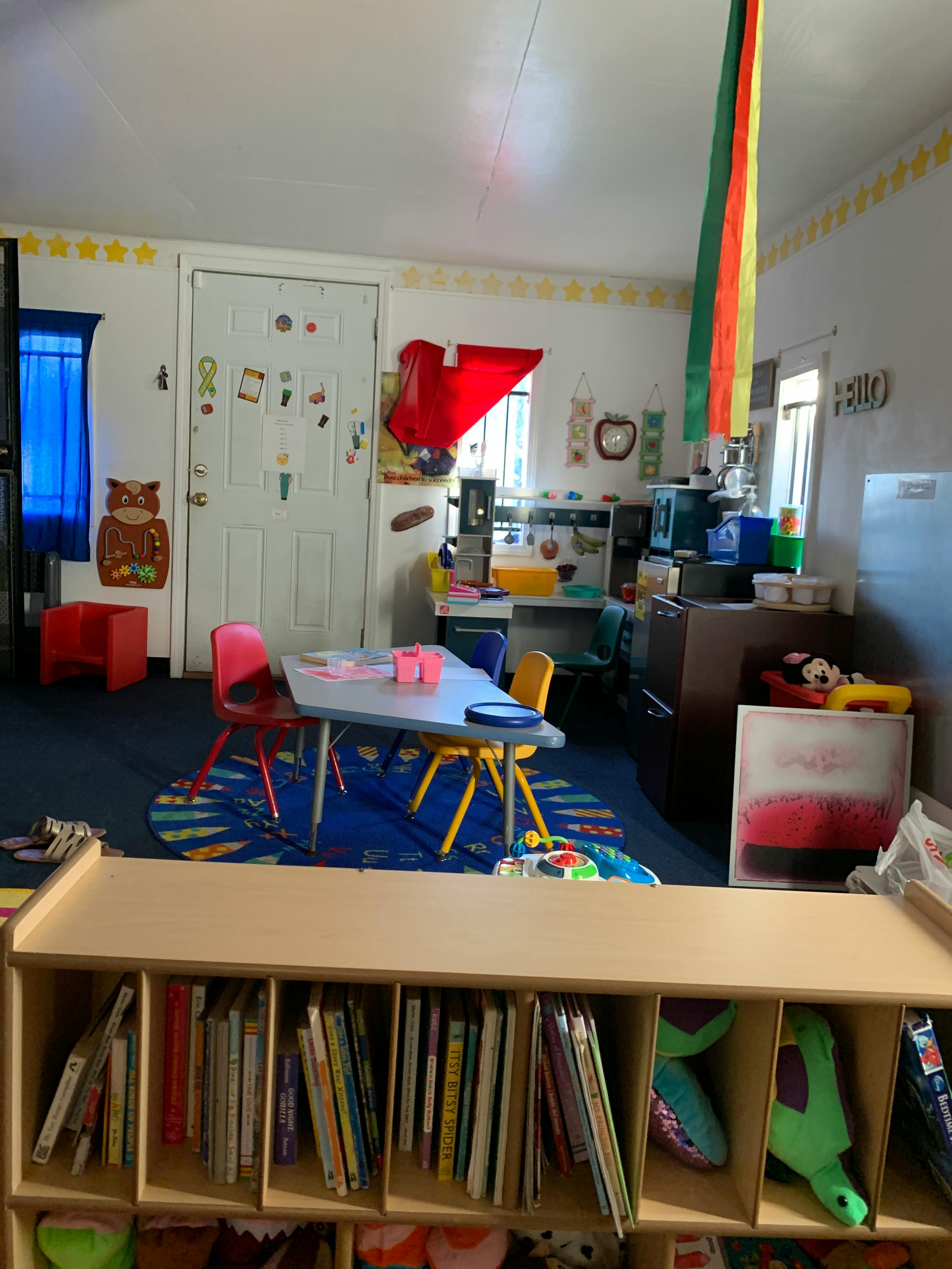 Classroom with small table and chairs, bookshelf, and decorated door