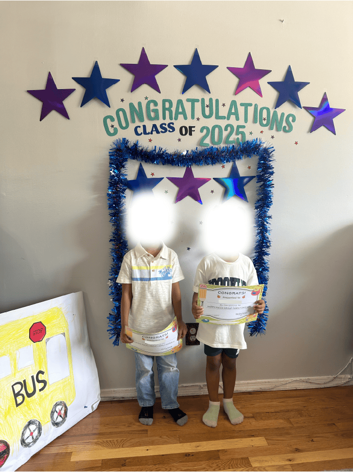 Two children holding certificates in front of a \