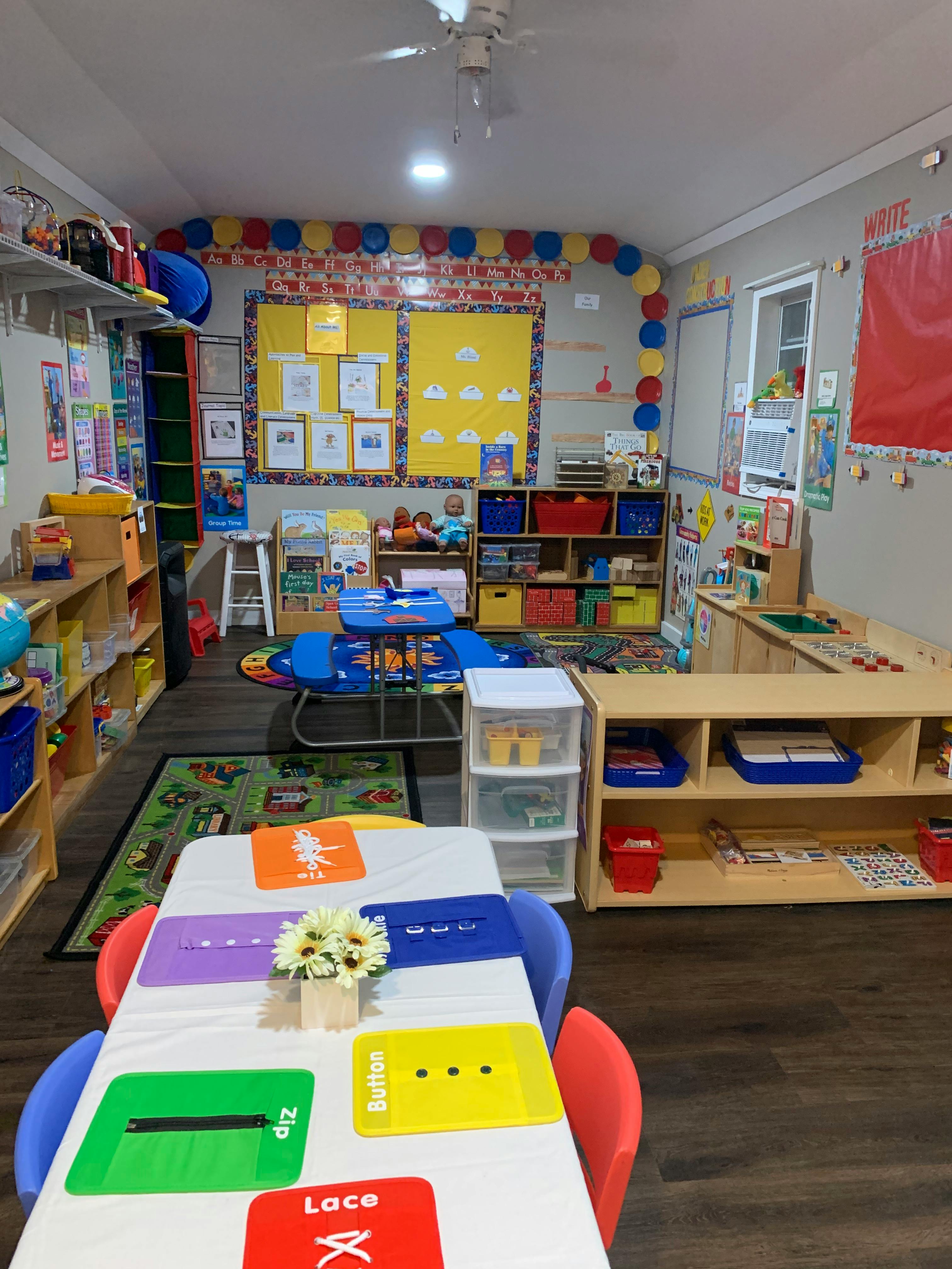 A classroom with tables, chairs, shelves, and learning materials