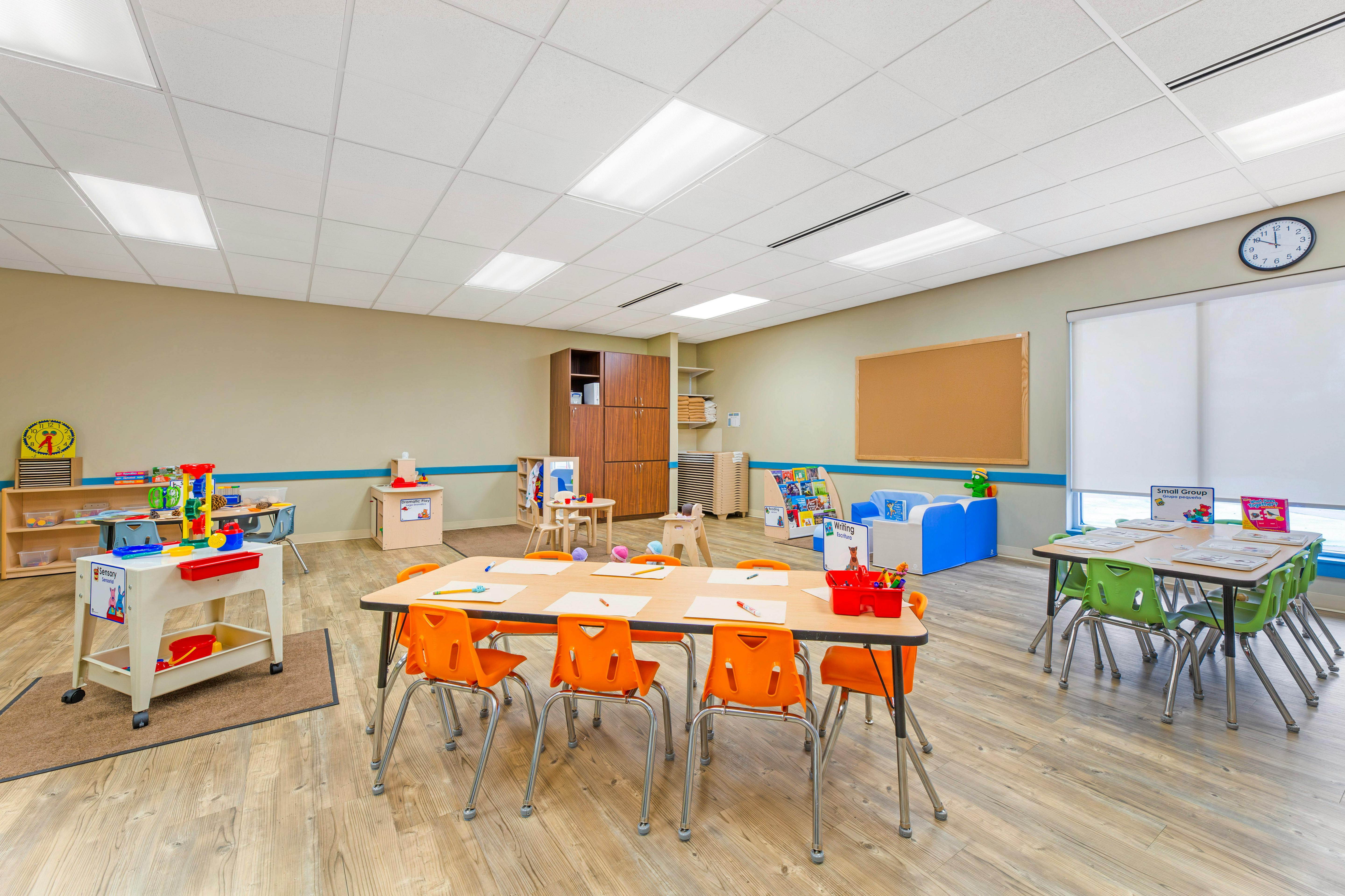 Classroom with multiple activity stations, tables, and chairs