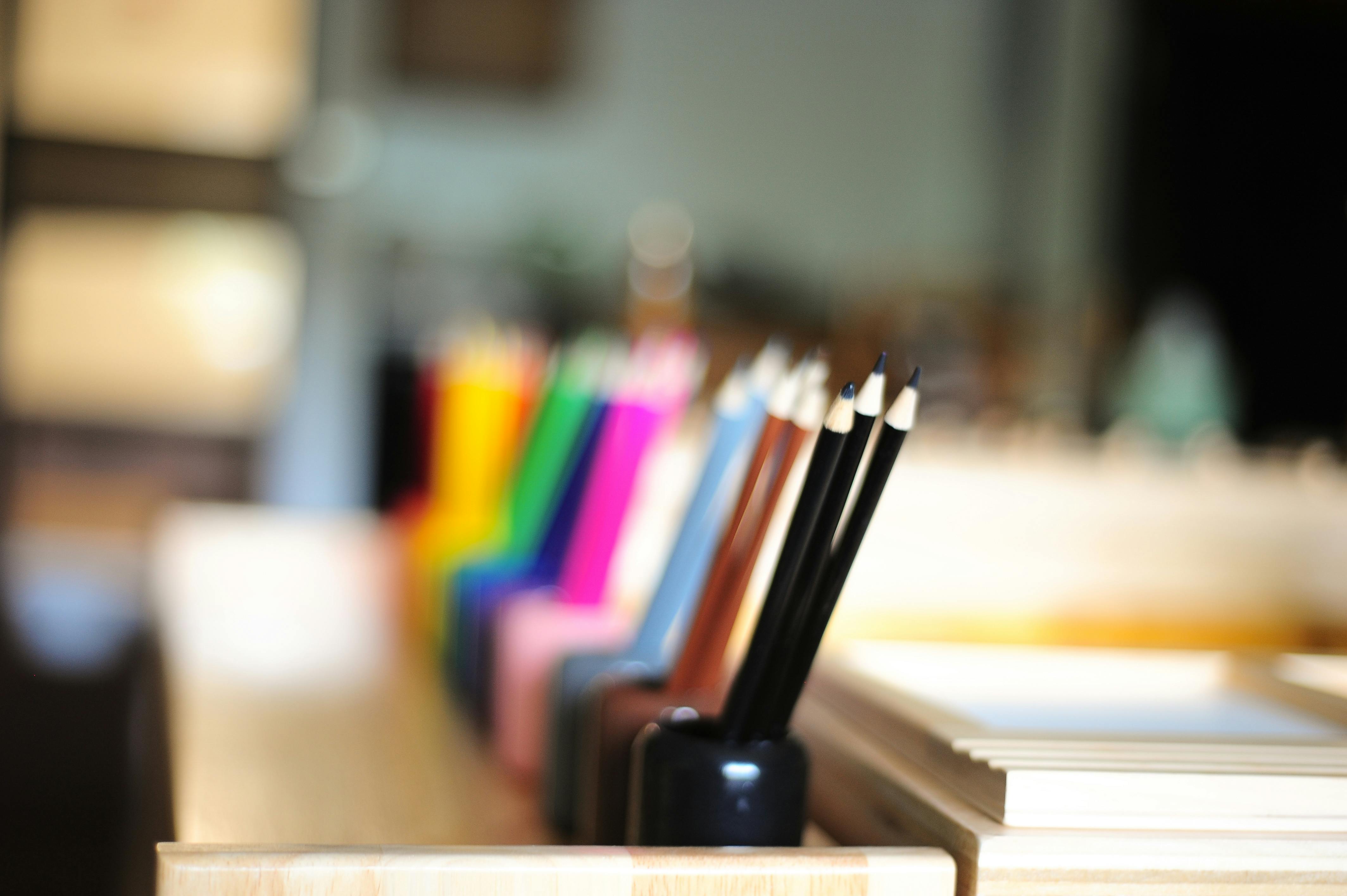 Pencils in a holder with other colorful pencils in the background