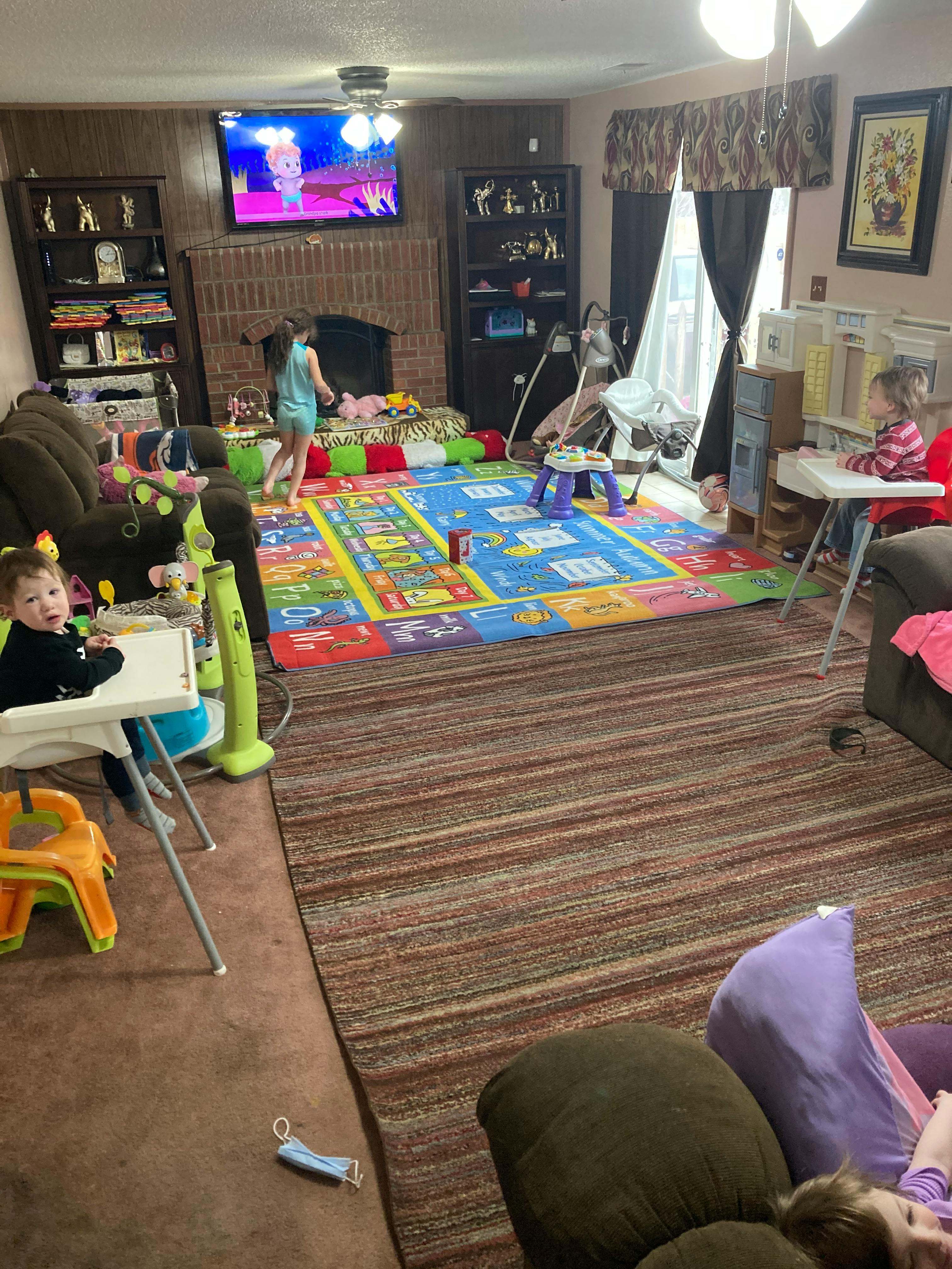 Children playing in a living room with a colorful rug