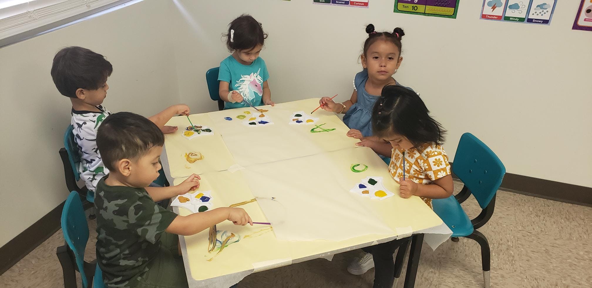 Four children sitting around a table with items on it