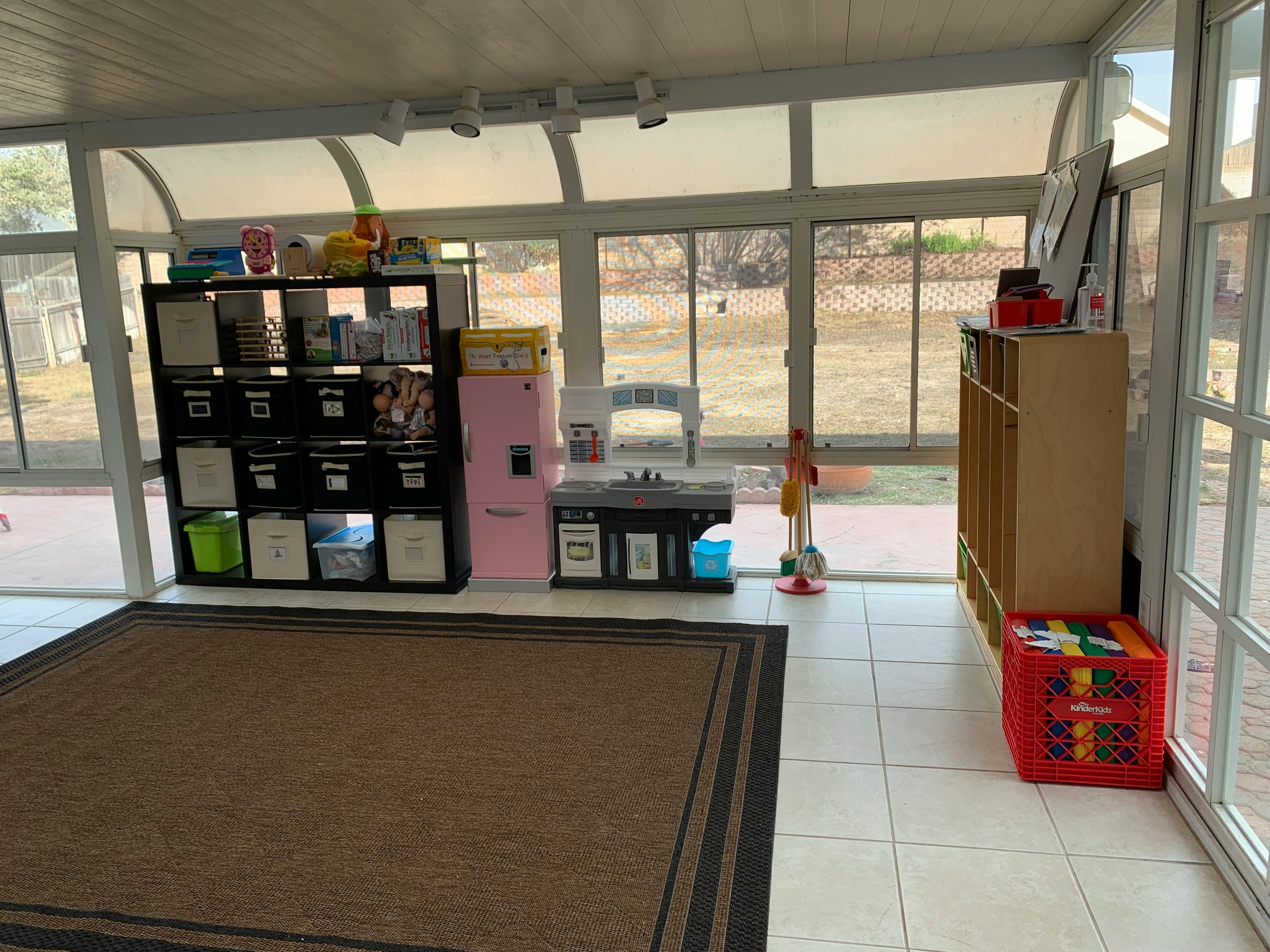 Sunroom with large windows, a brown rug, and storage shelves
