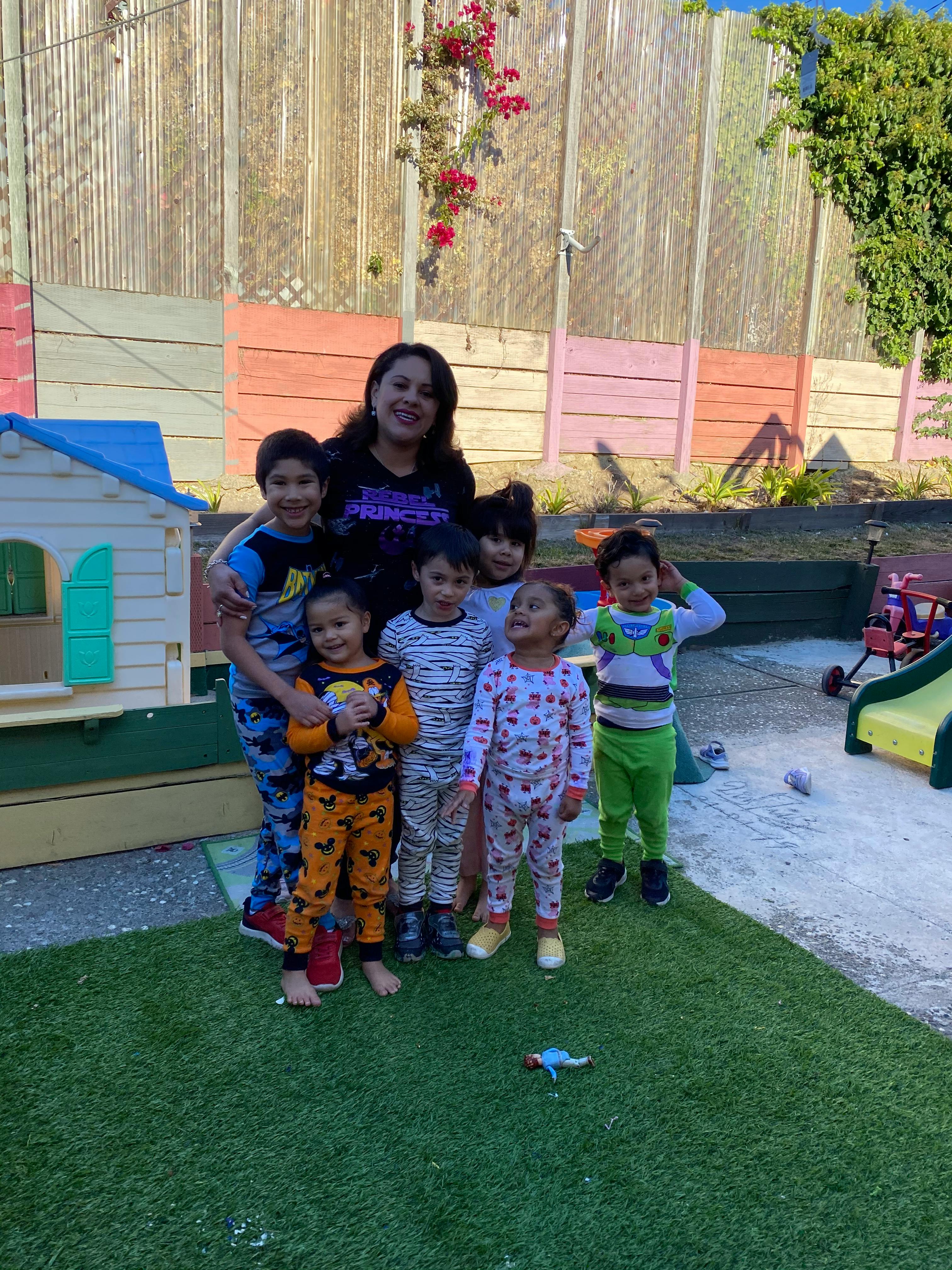 Adult person with a group of children in pajamas outdoors