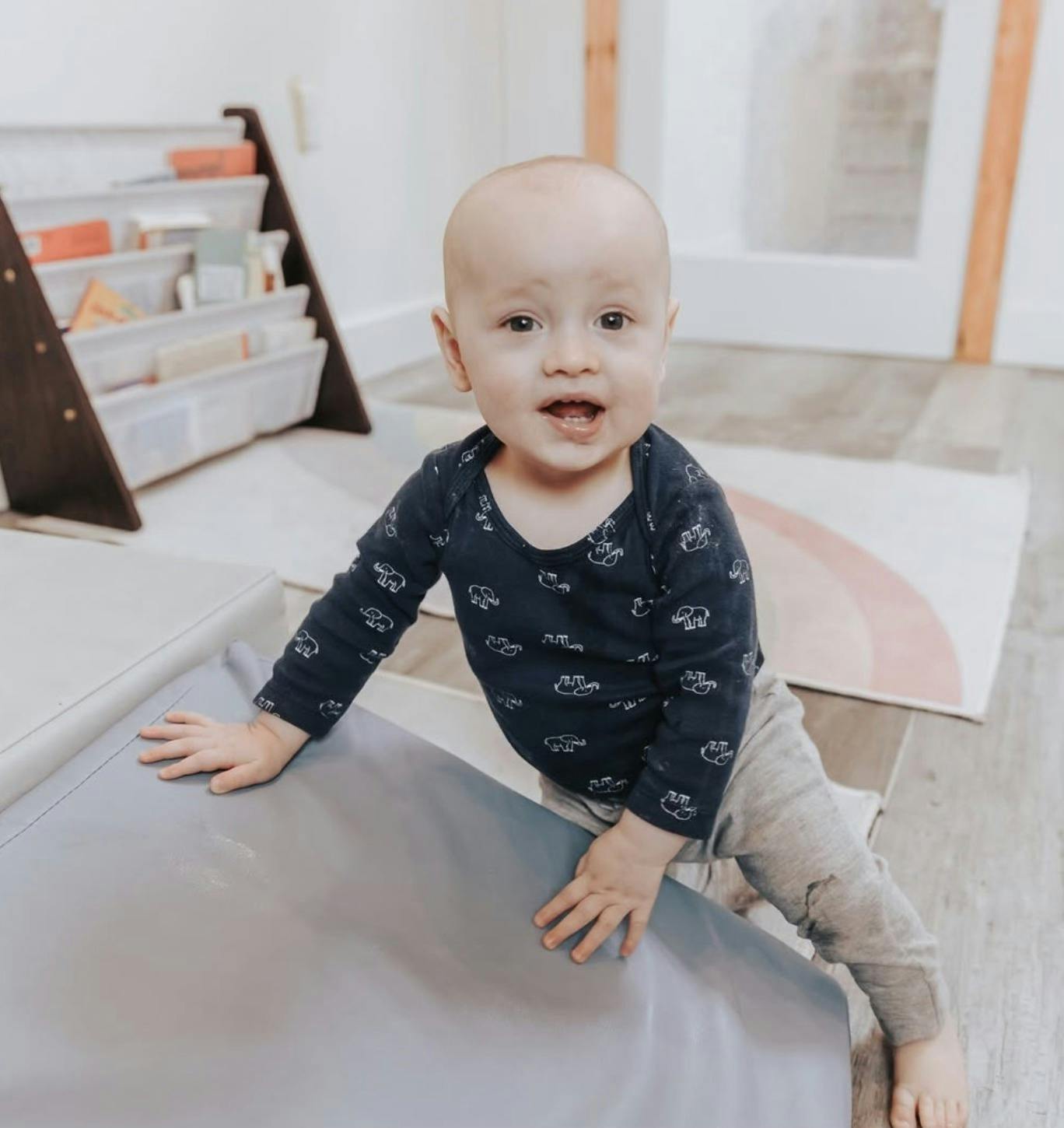 Child on hands and knees on a play mat