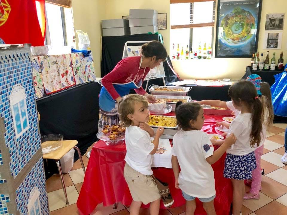 Person serving food to children at a table