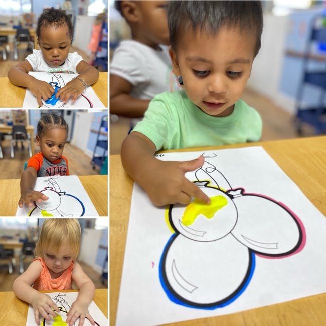 Multiple children finger painting on paper with balloon outlines
