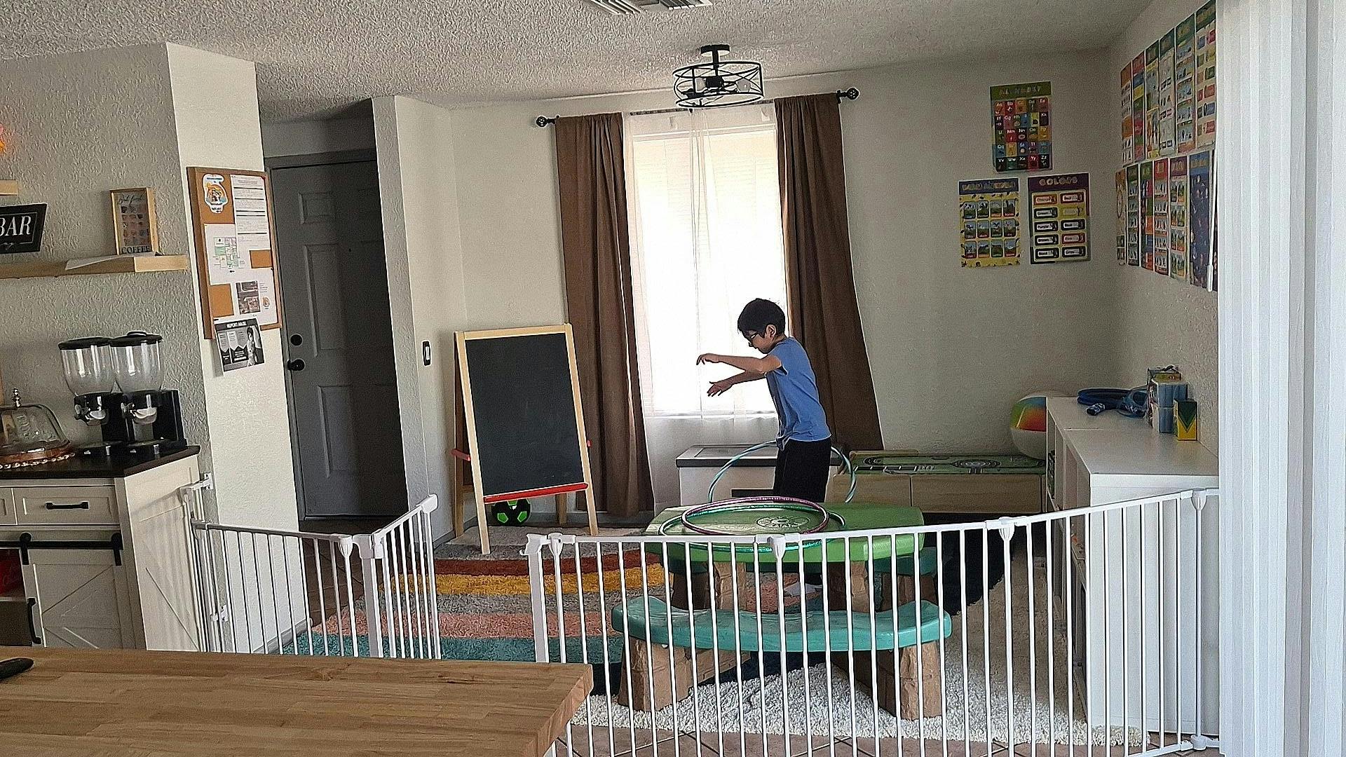 child in a living room standing by a window