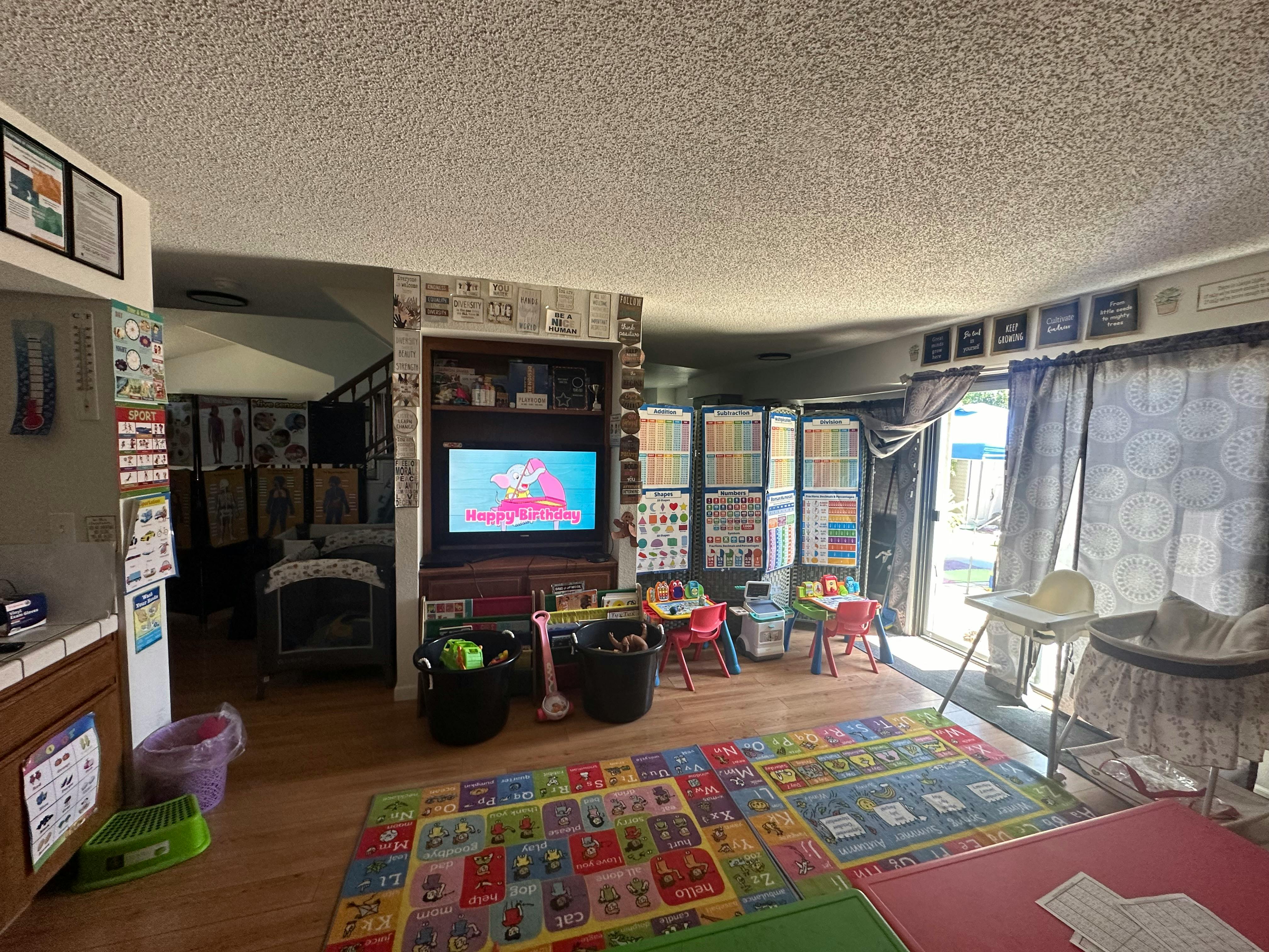 Living room with a TV, play mats, and child-sized furniture