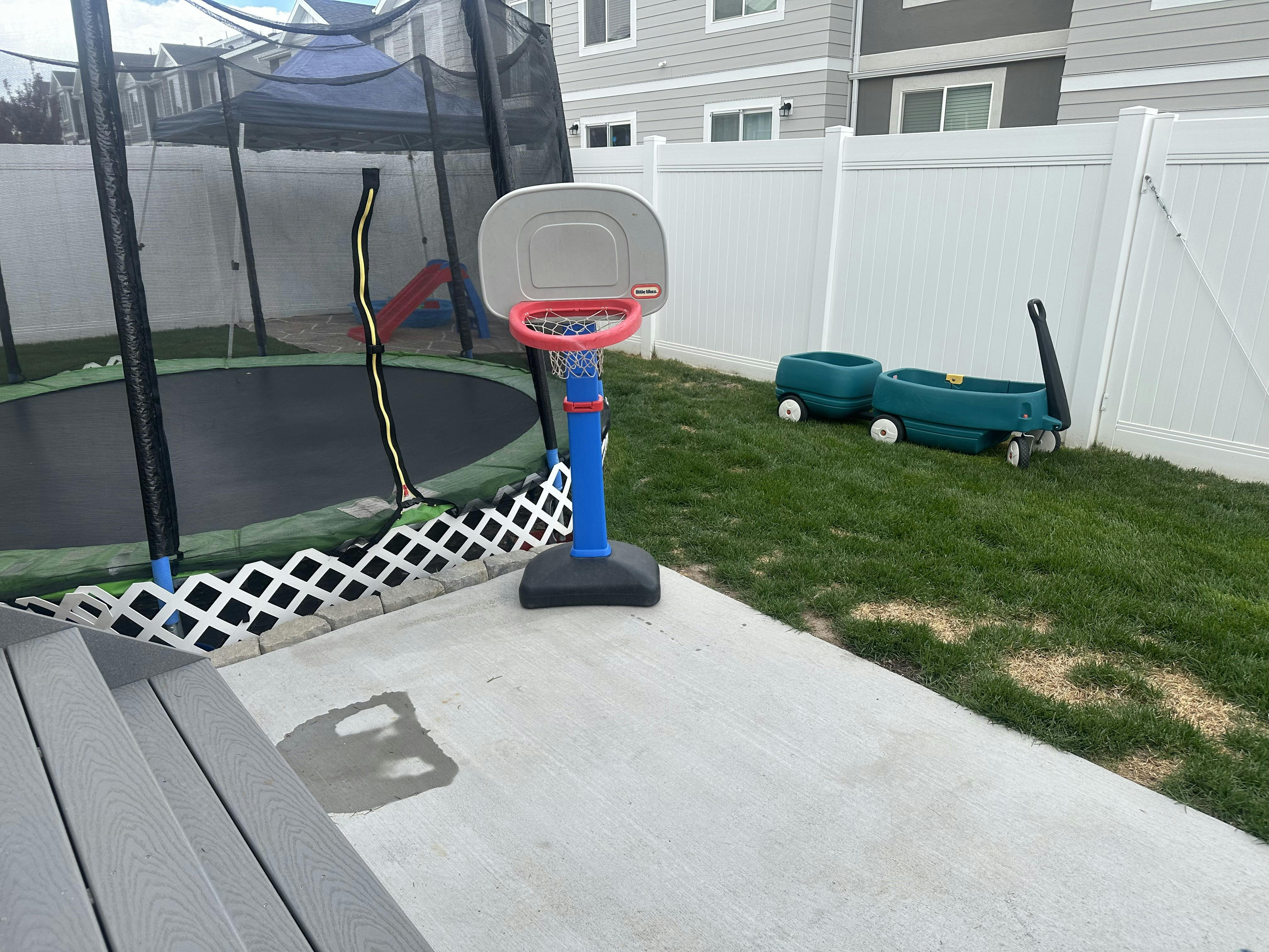 Trampoline and basketball hoop in a backyard