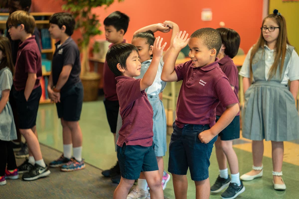 Children in uniform playing a clapping game