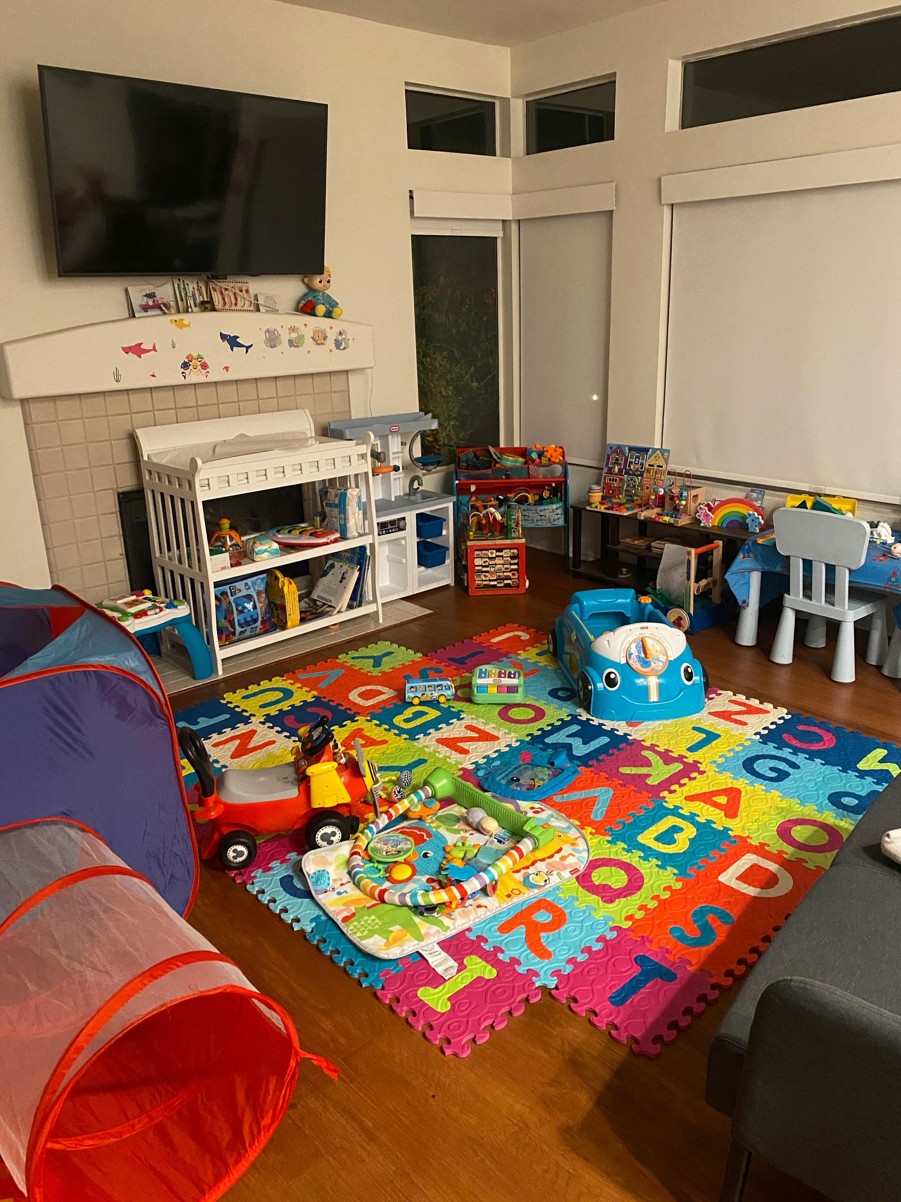 Playroom with colorful alphabet mat and various toys