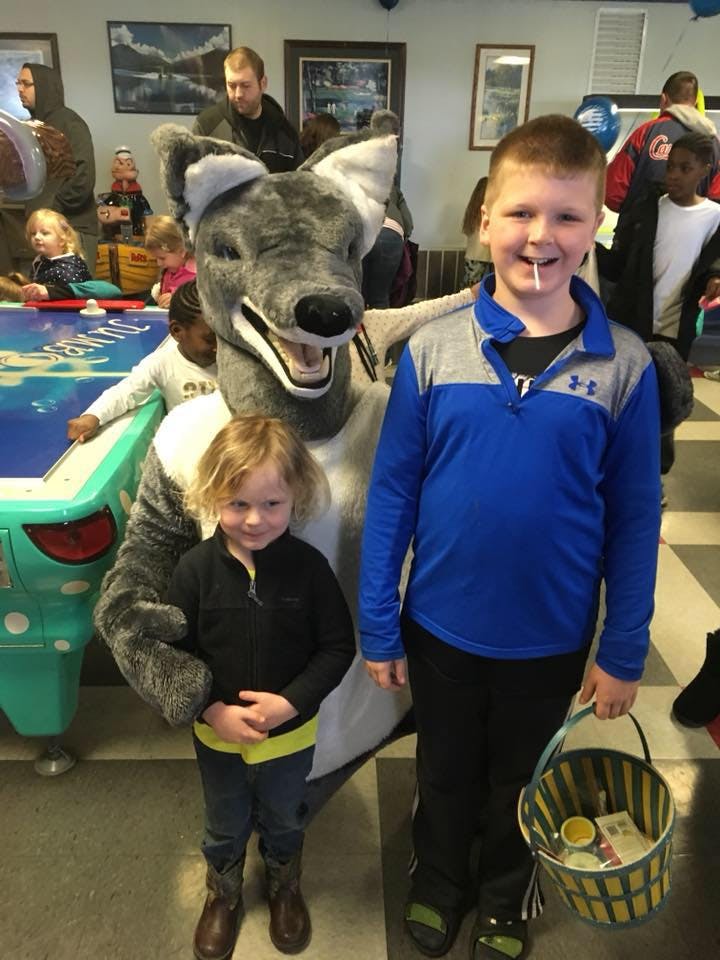 Mascot with two children, one holding a basket