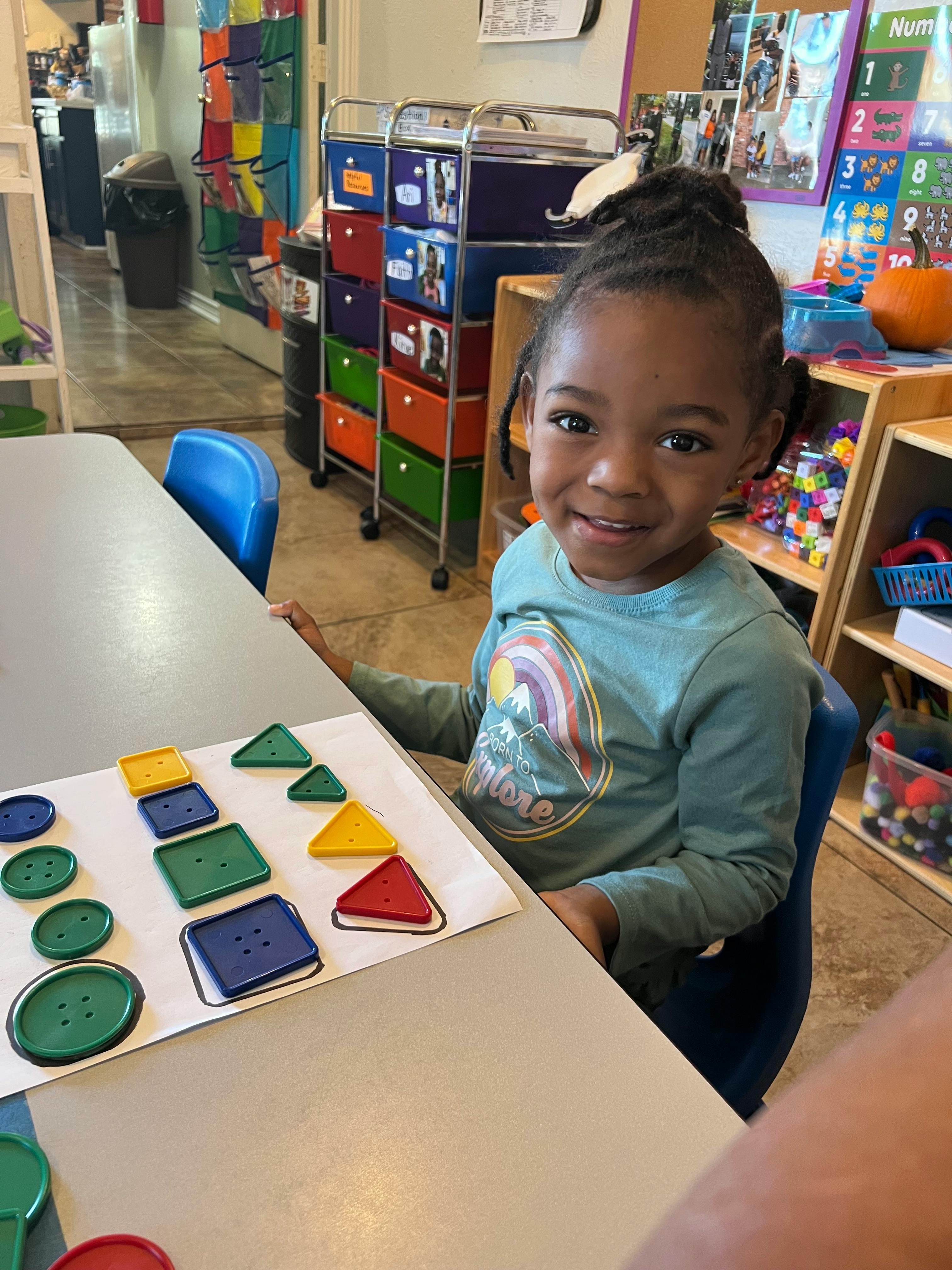 Child at a table with shape sorting activity
