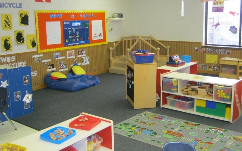 Classroom with play area, toys, beanbag chairs, and an indoor wooden staircase