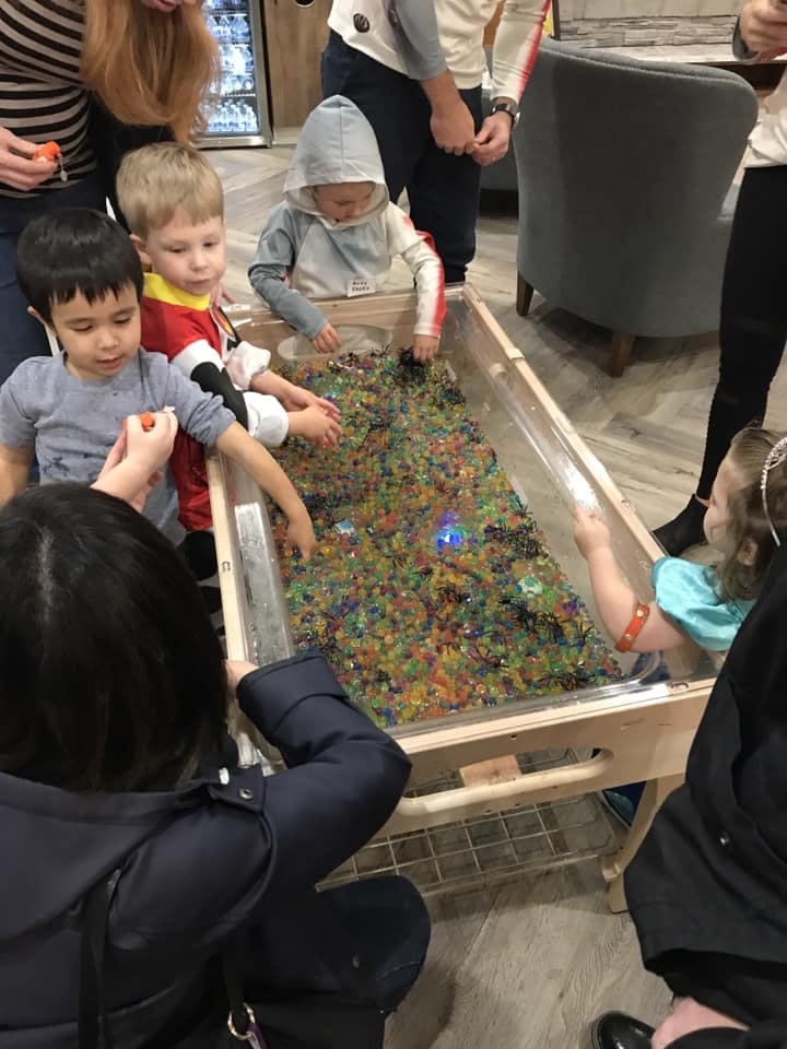 Children playing with colorful beads in a sensory table