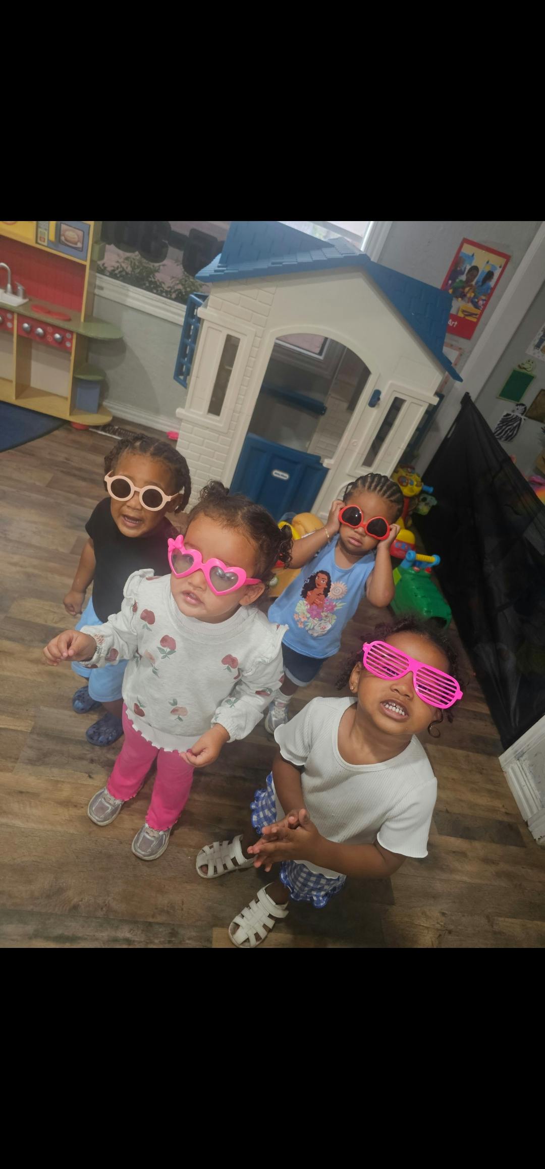 Four children wearing novelty sunglasses in a playroom
