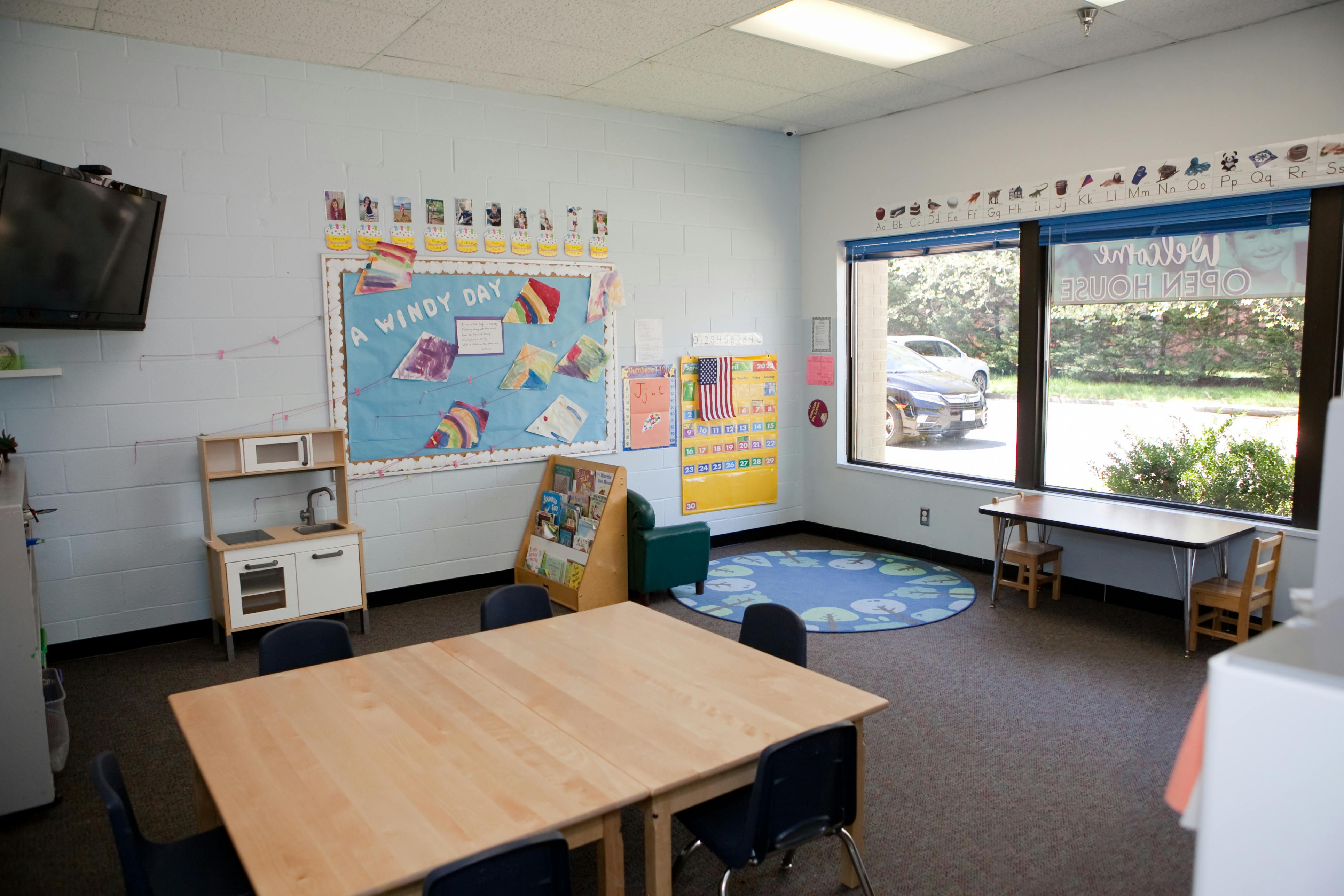 Classroom with tables, chairs, and a bulletin board