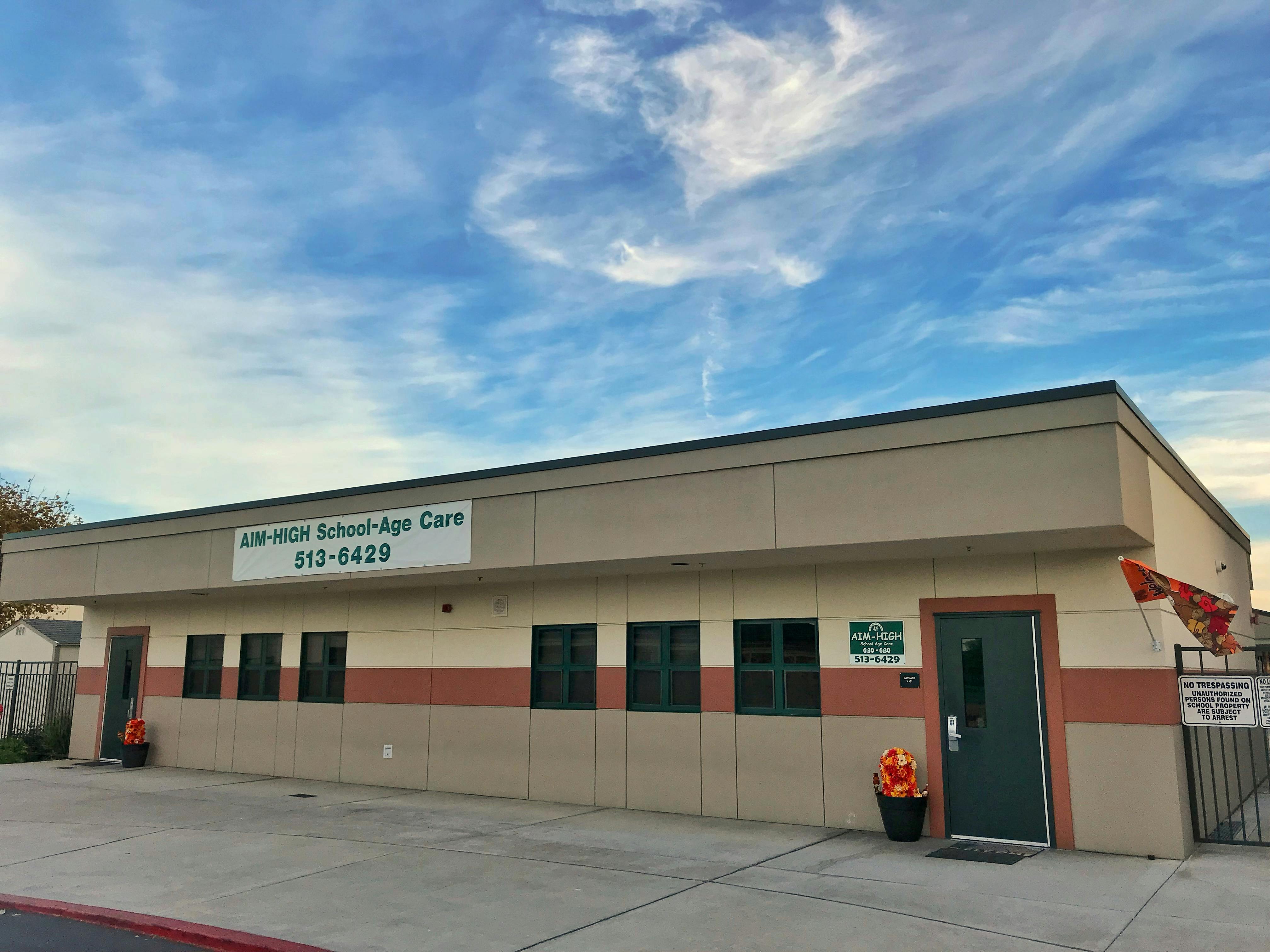 Building with a sign that reads "AIM HIGH School-Age Care"
