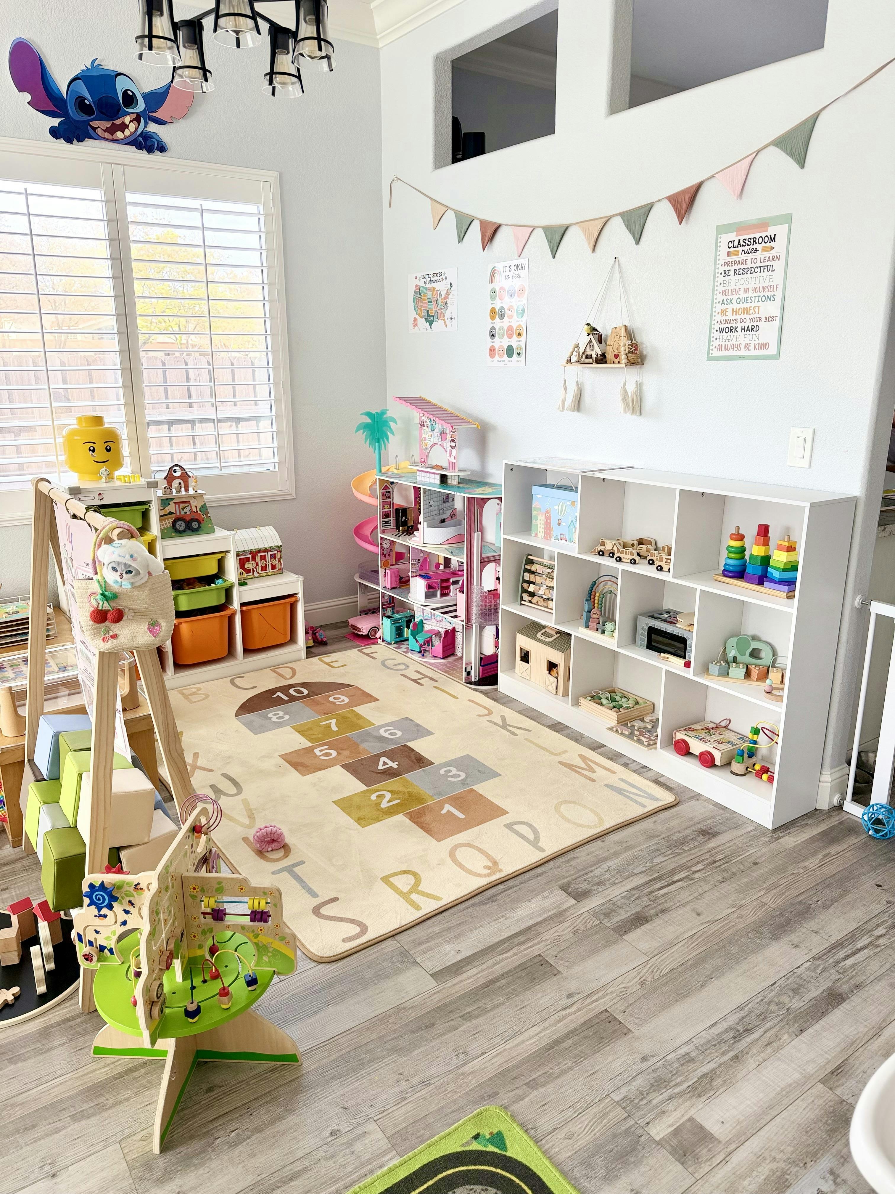 A children's playroom with various toys, shelves, and a hopscotch rug