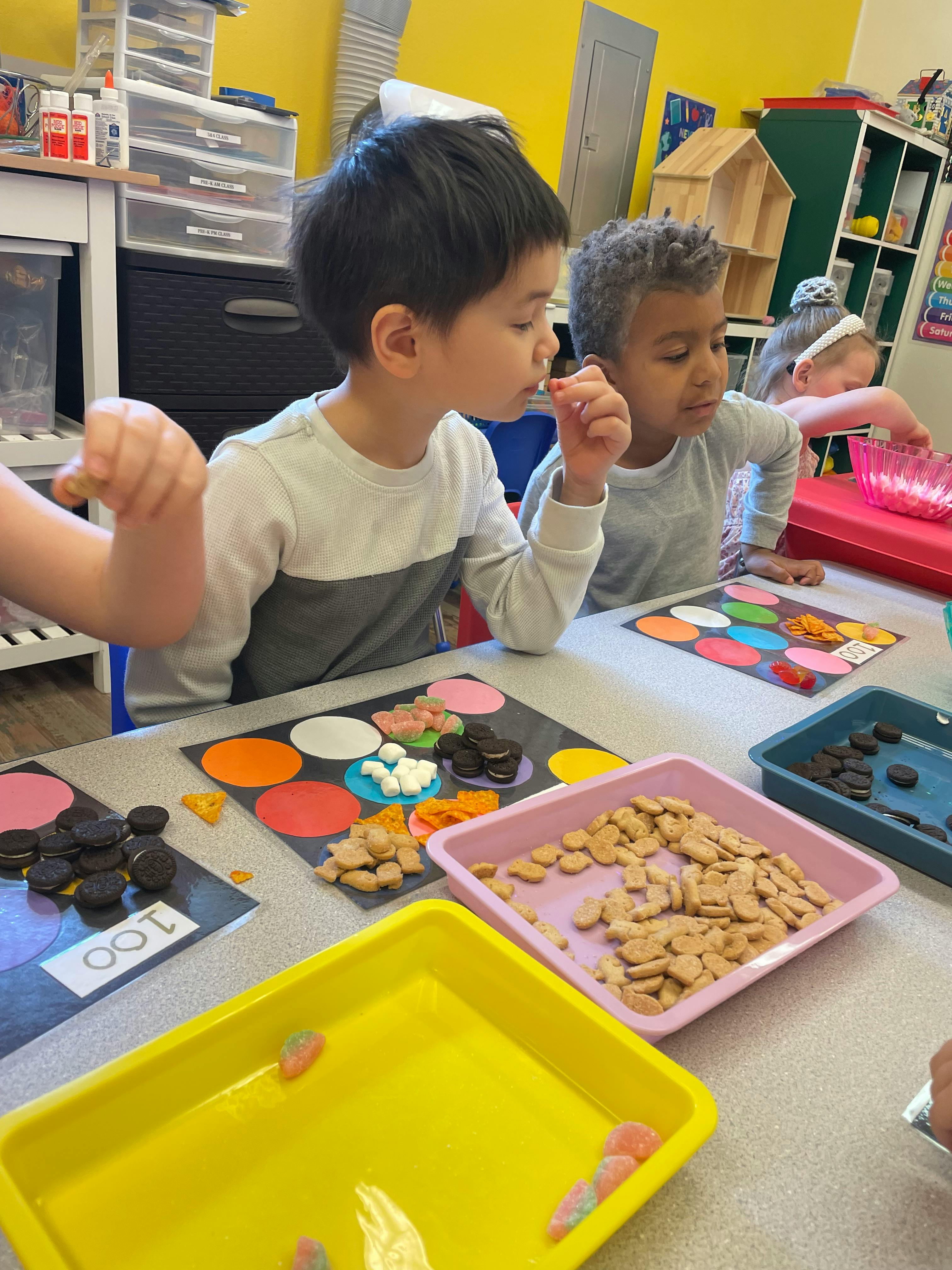 Children at a table with snacks and colorful mats