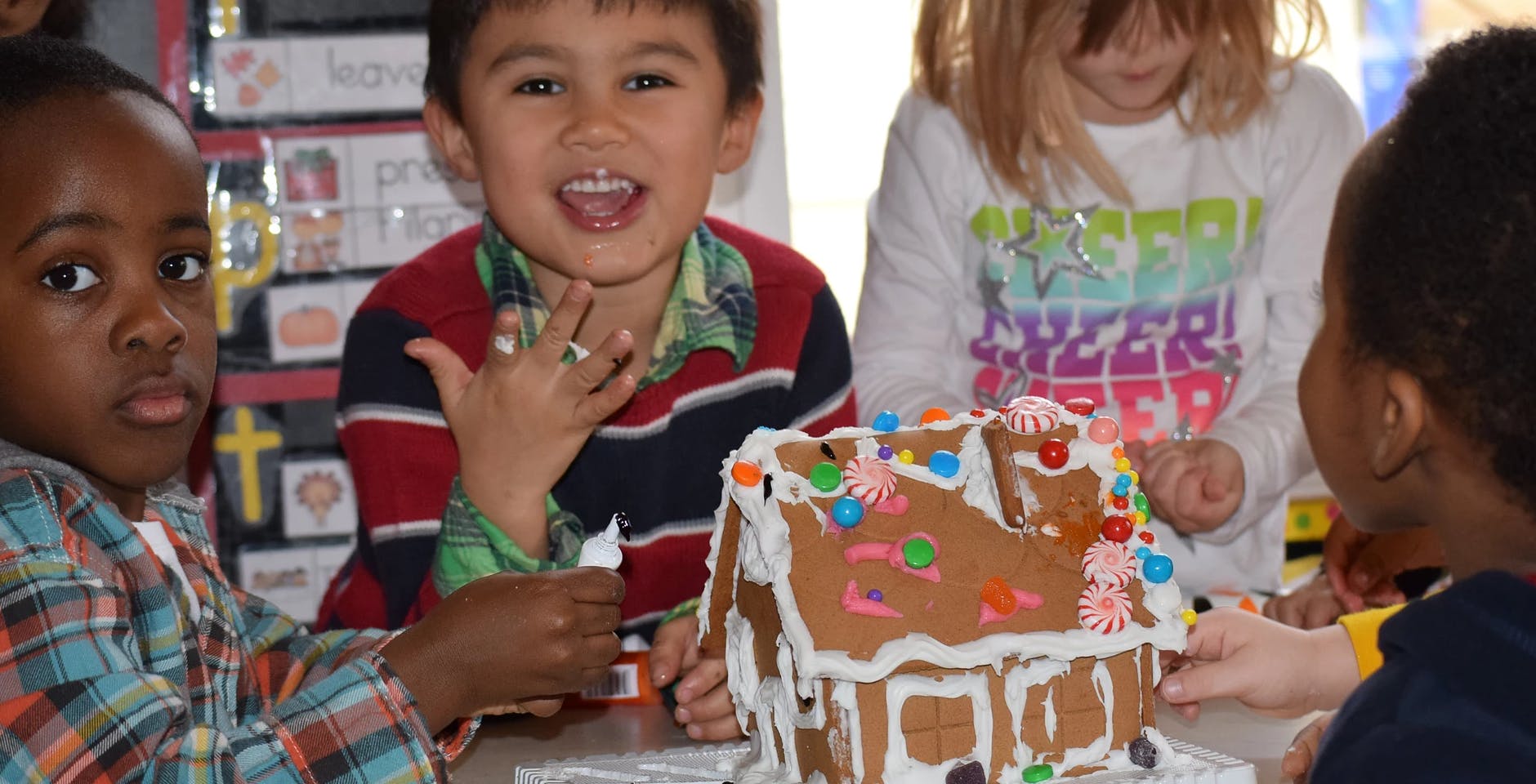 Children decorating a gingerbread house