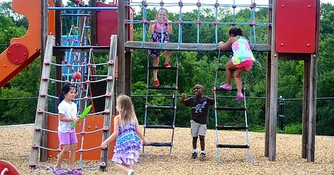 Children playing on playground climbing structures