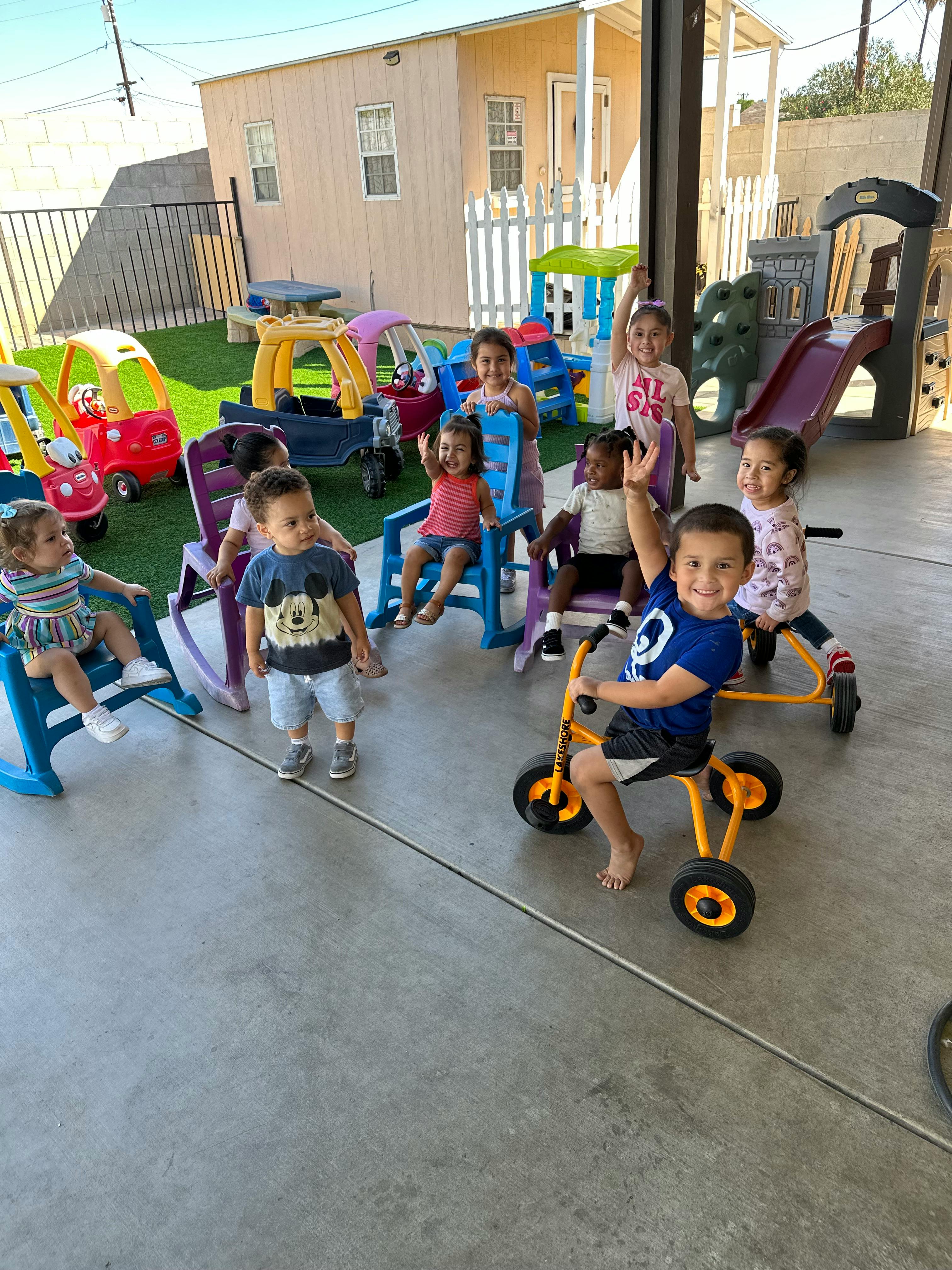 Children playing with toys and riding tricycles outdoors