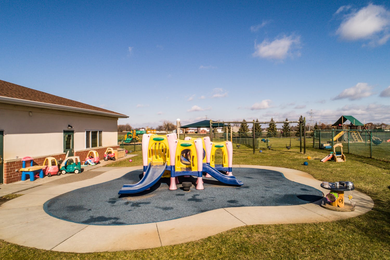 Outdoor playground with slides and a building in the background