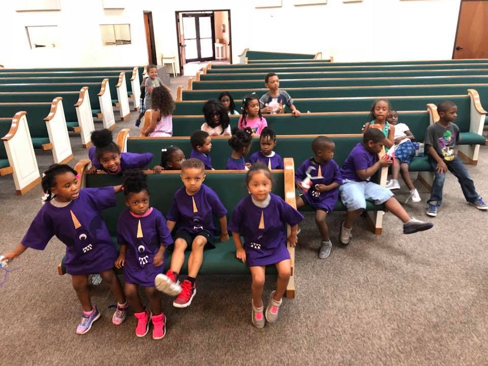 Group of children and teens sitting in rows of pews
