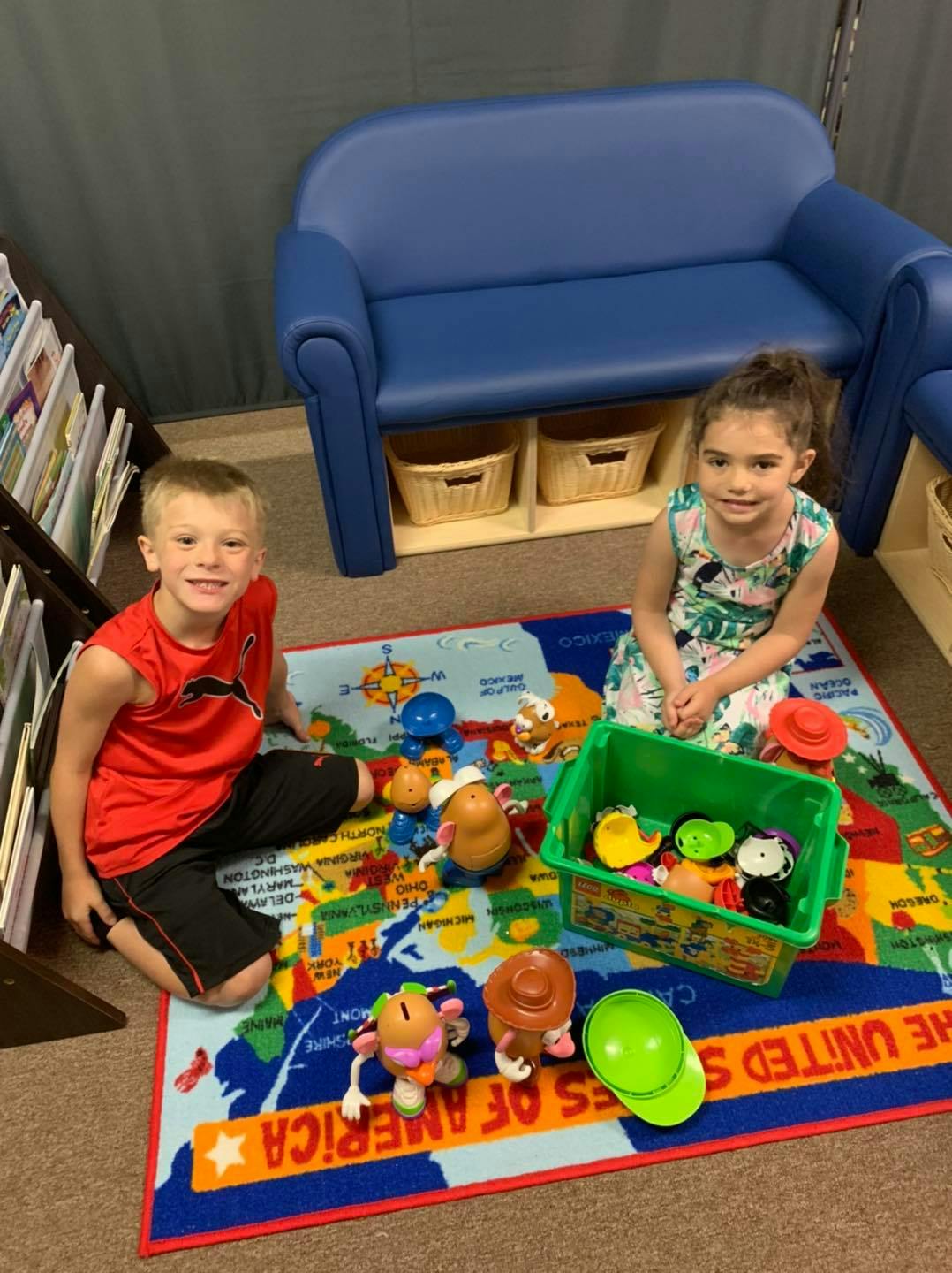 Two children playing with toys on a rug