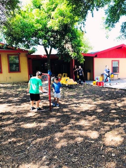 Two children playing outdoors near a building